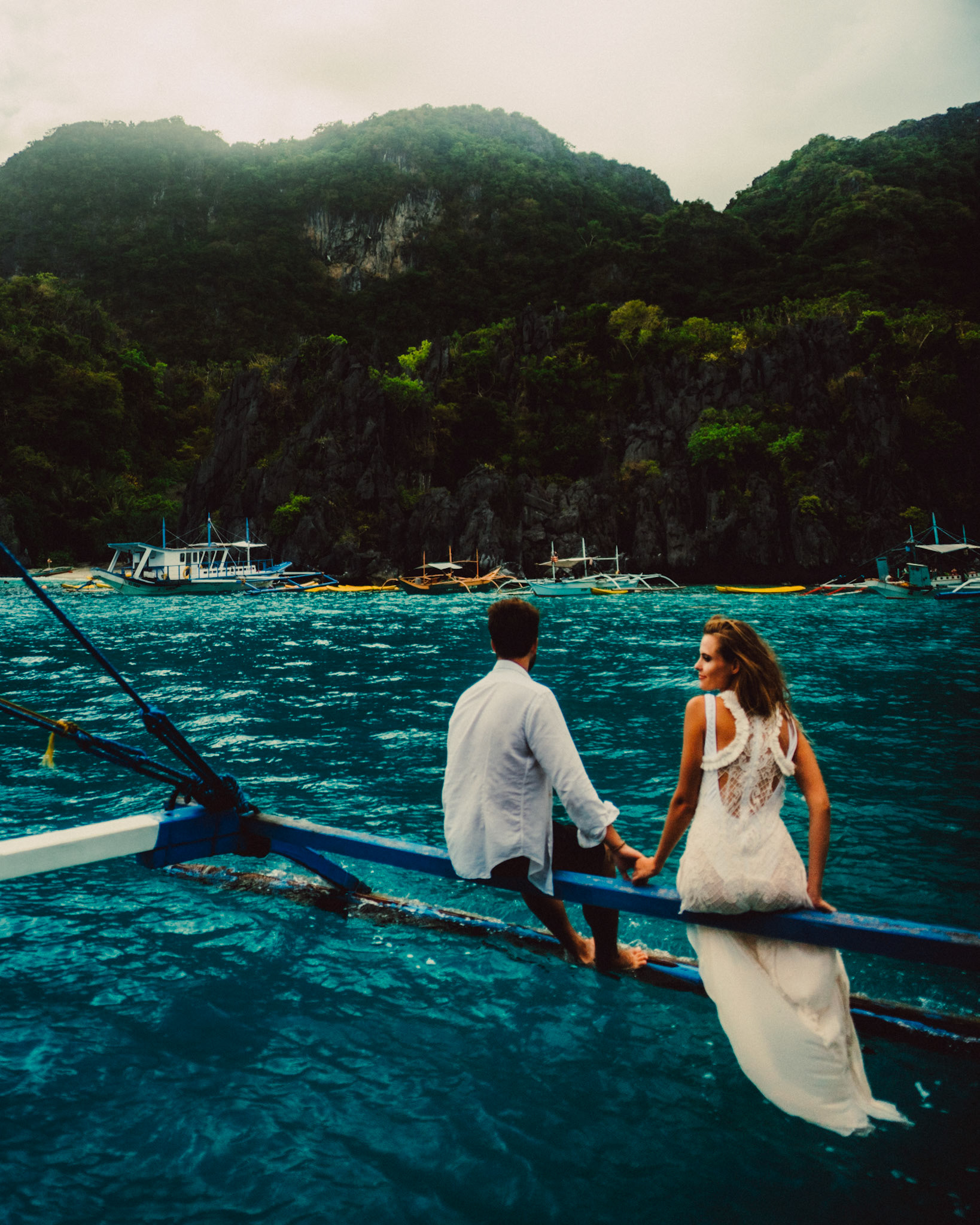 A couple sitting on an outrigger boat outside the Small Lagoon, El Nido, Palawan, Philippines, Southeast Asia, December 2019, Sony A7III.
