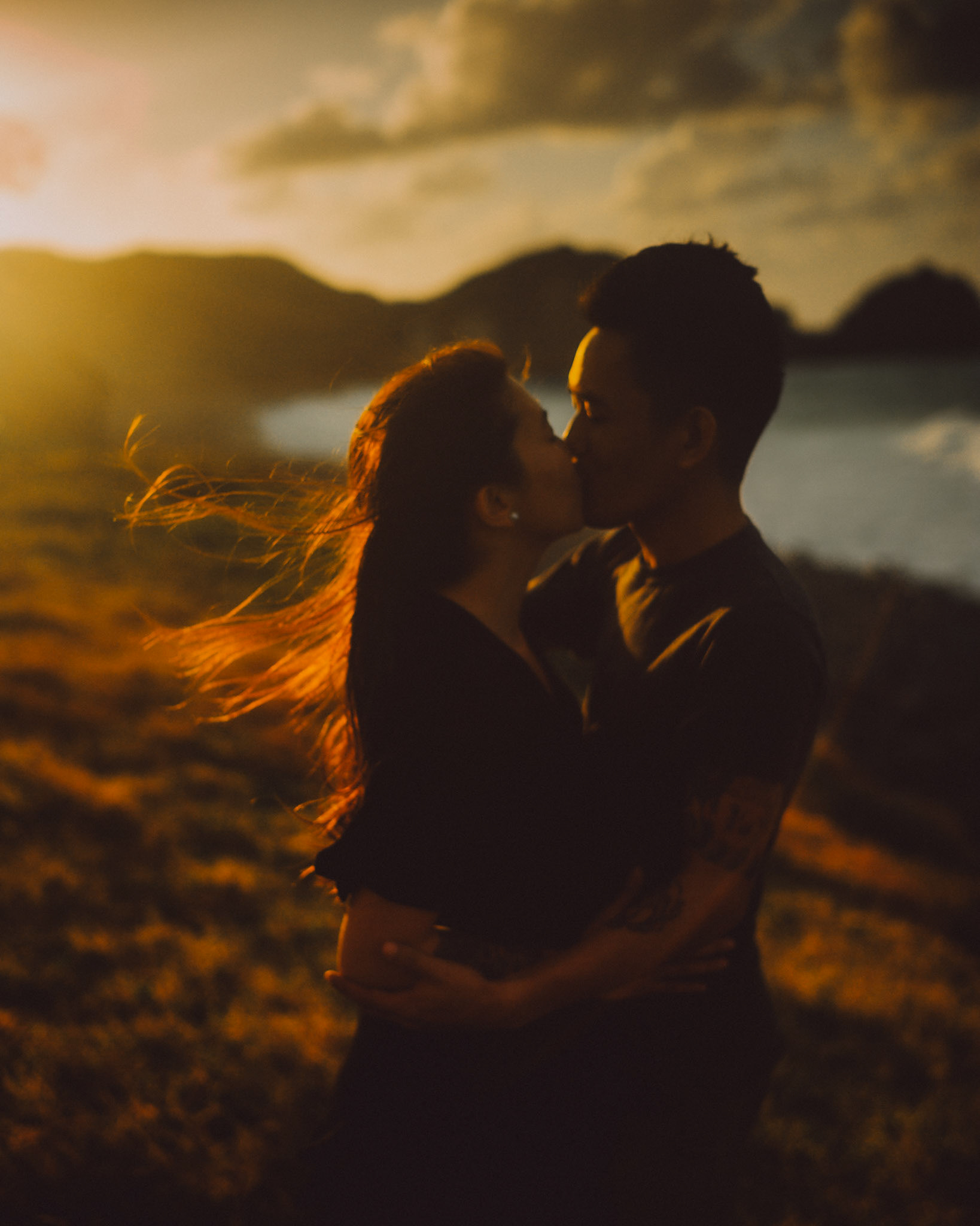 Intimate couple portraits on a seaside cliff just moments before sunset, from Owen and Nikka's adventure prenup photoshoot in Chadpidan Boulder Beach, Batanes, Philippines, Southeast Asia, October 2017, Leica M.