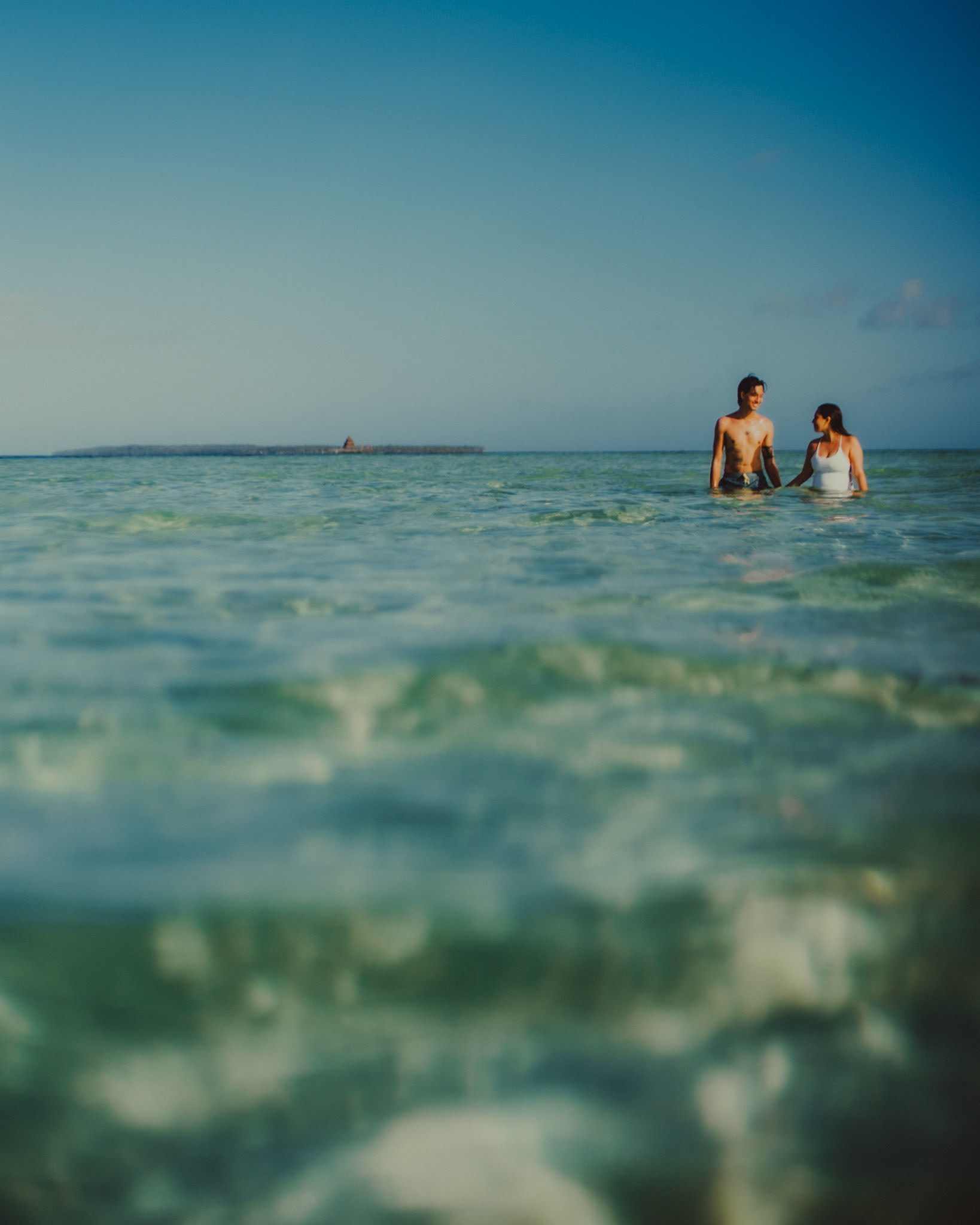 Waist-deep in clear and turquoise water on a submerged sandbar in Malinao Paradise, from Jeo and Bianca's island hopping honeymoon couple portrait shoot in Siargao Island, Philippines, Southeast Asia, February 2020, Sony A7III