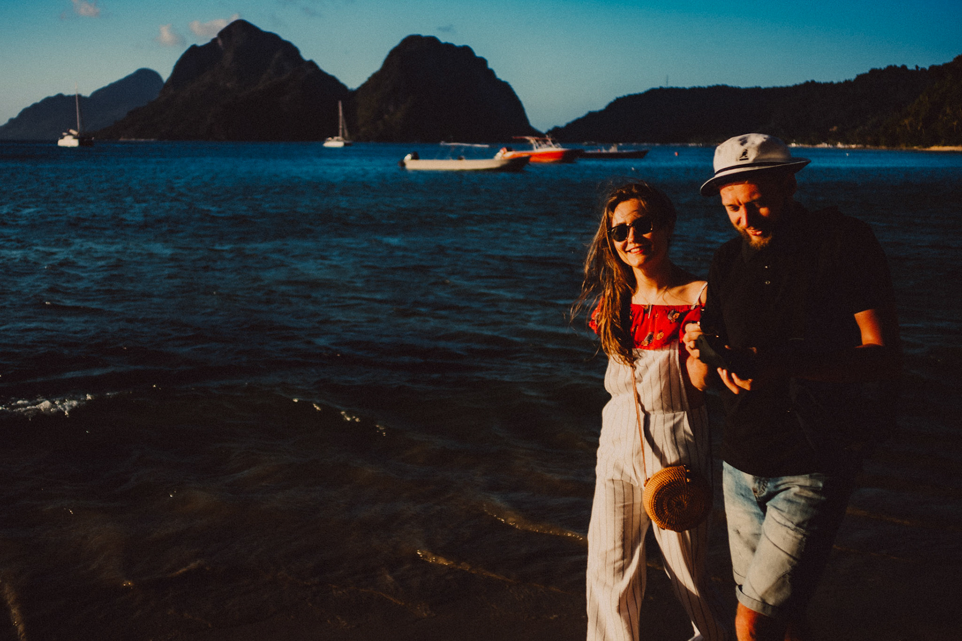 A travel couple walking along Maremegmeg Beach shortly before sunset, El Nido, Palawan, Philippines, Southeast Asia, February 2019, Sony A7III.