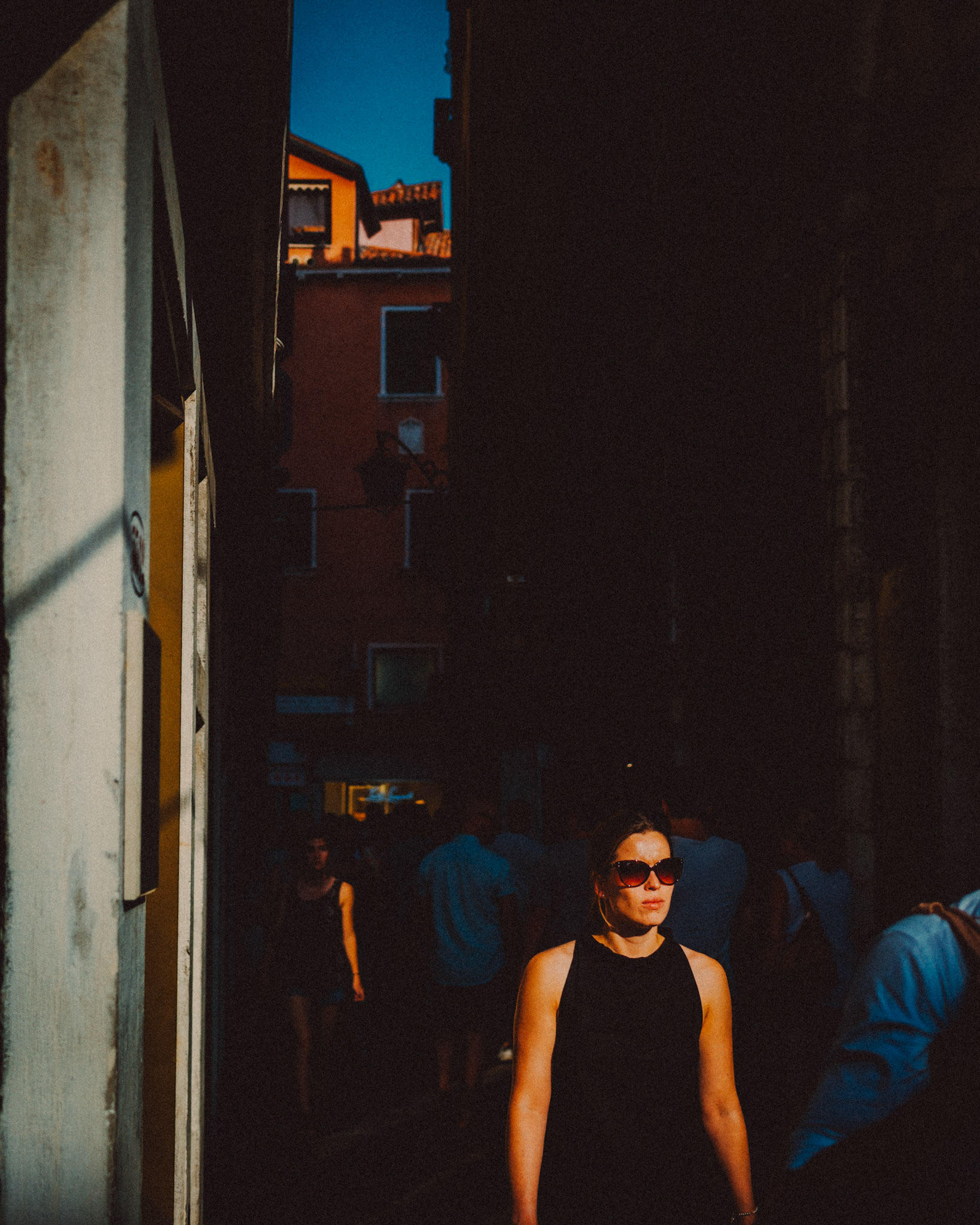 An Italian woman wearing sunglasses, under harsh lighting, Venice, Italy, August 2017, Leica M.