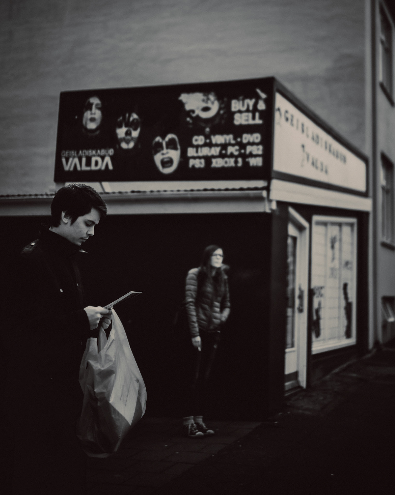 A street snapshot outside Geisladiskabúð Valda used CD store, in black and white, Reykjavík, Iceland, May 2016, Leica M.