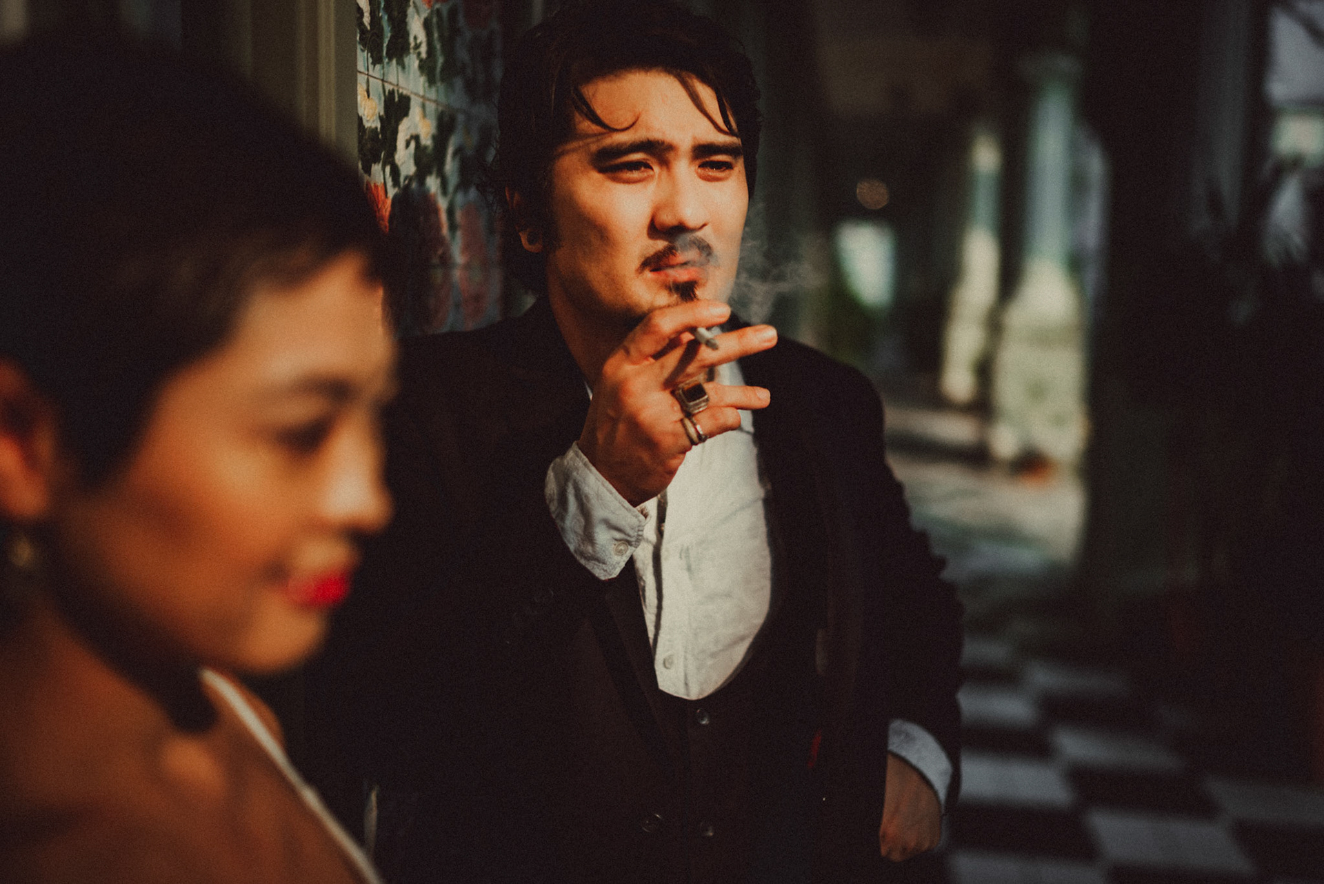 A Japanese couple sharing a lighthearted moment in a sunlit corridor with Peranakan details, from Ibuki and Emi's artsy moody engagement shoot, Pertain Road, Little India, Singapore, October 2015, Sony A7S.