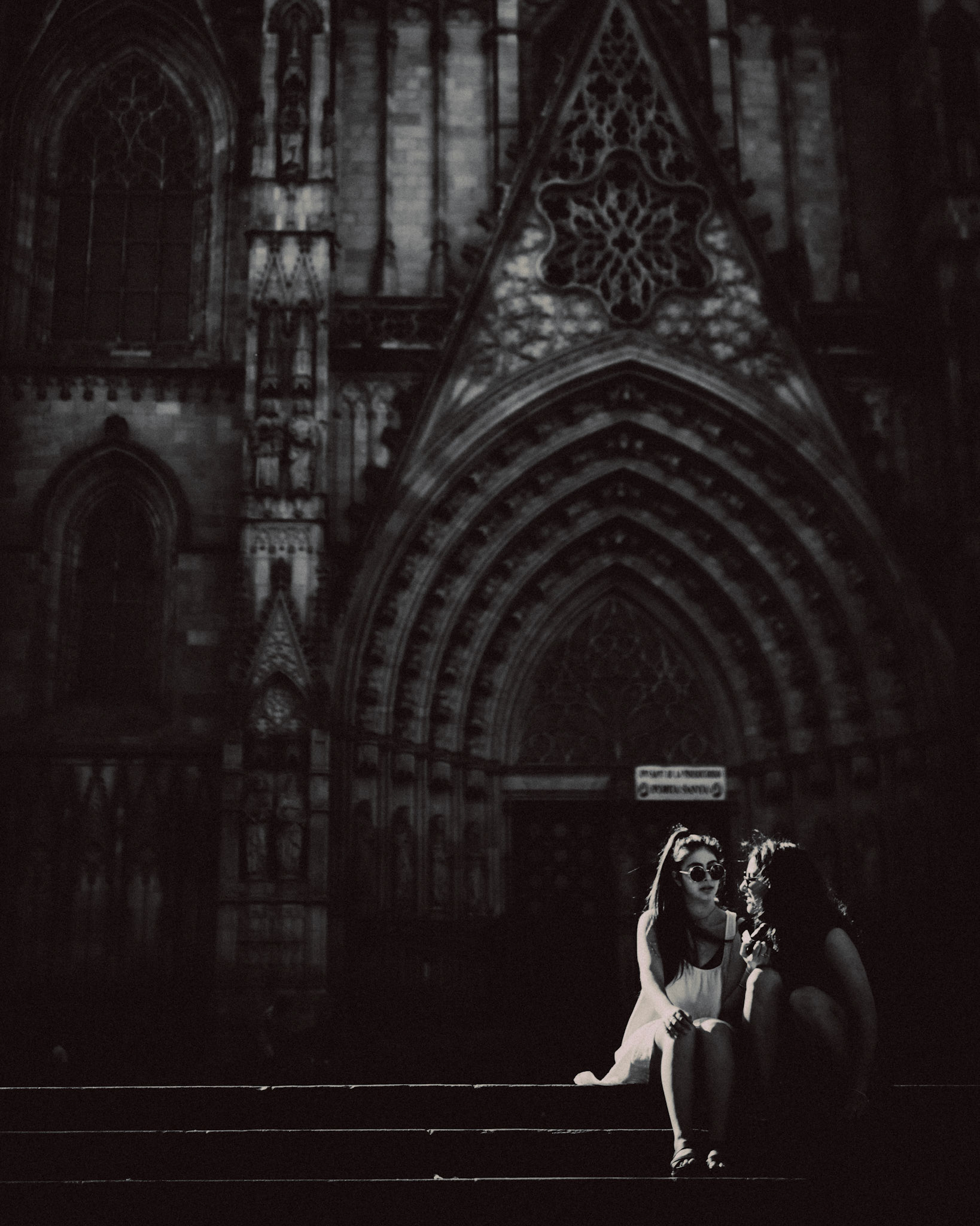 Two teenage girls in front of the Barcelona Cathedral, in black and white, Barcelona, Spain, July 2016, Leica M.
