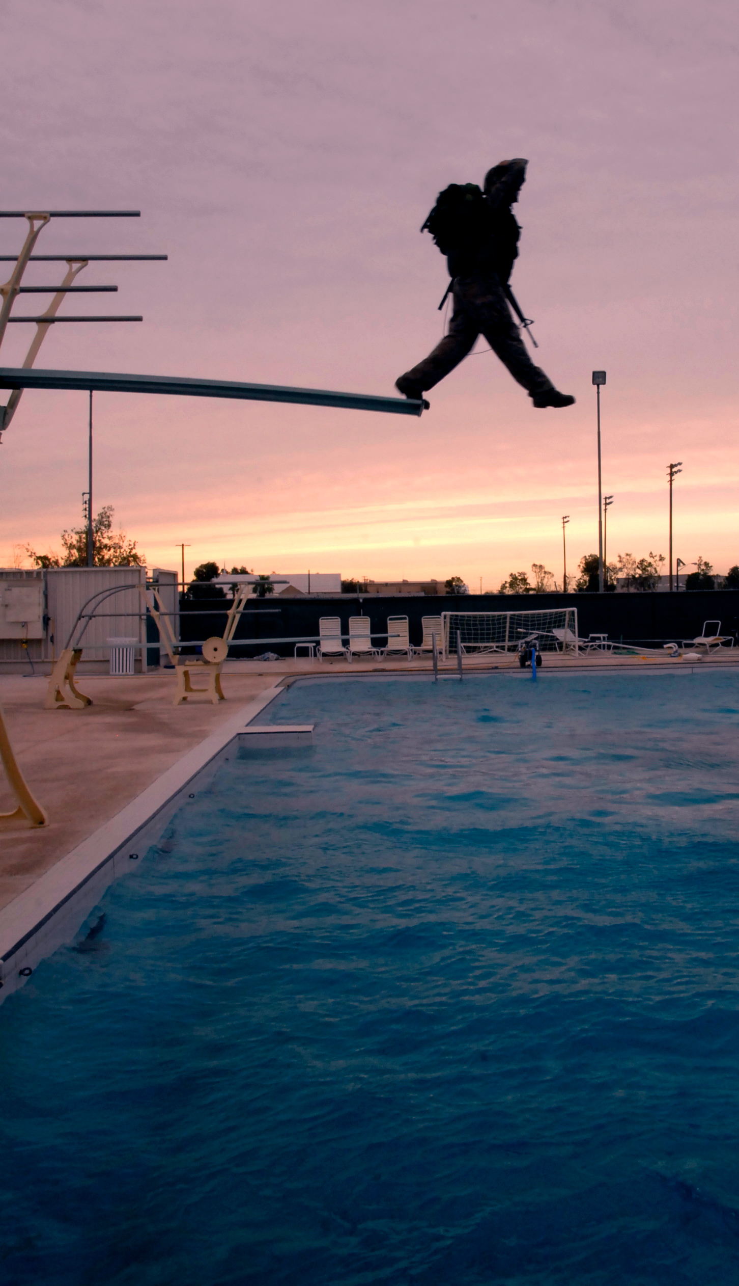 In full combat gear, Lance Cpl. Brittney Garland, a military policeman from the Marine Corps Air Station Yuma, Ariz., steps off a diving board during water survival training at the Naval Air Facility El Centro, Calif., June 5, 2009. Throughout June 1-5, 2009, Yuma Headquarters and Headquarters Squadron Marines tested for various qualification levels of combat water survival.