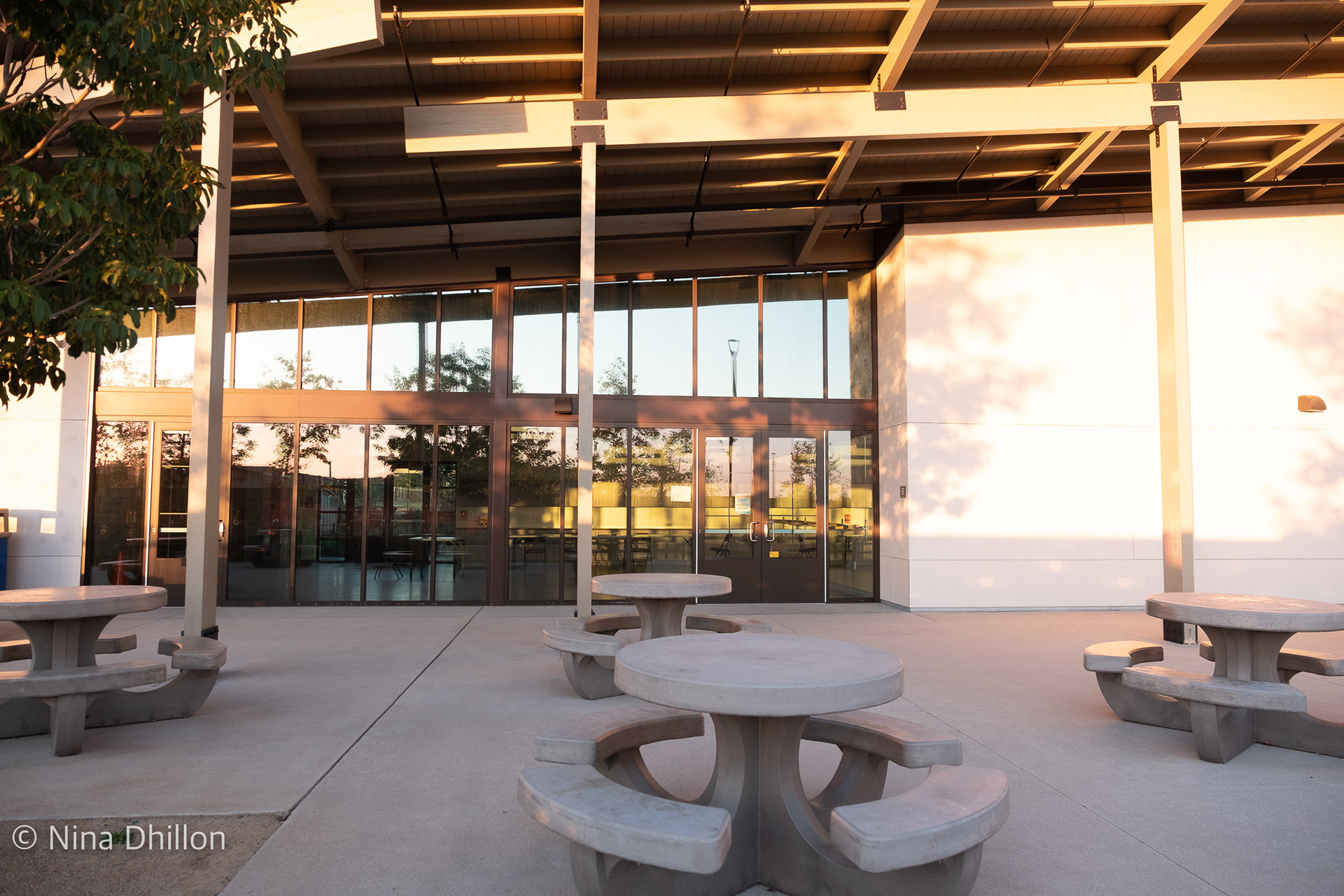 SYMMETRY/REFLECTION: October 20,2021. Pacific Highlands Rec Center, San Diego. The lines from the column, the doors and the symmetry of the round tables across. 1/60 Sec at f/3.2 ISO 250