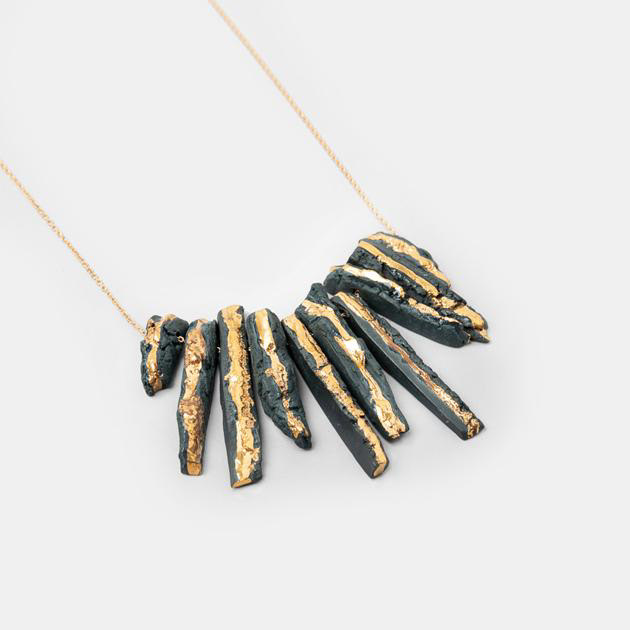 Collier pièce unique - Décor en pierres de porcelaine noire ou blanche teintée dans la masse émaillée transparente et ornée de touches d’or liquide - Taille des pierres de porcelaine : de 3 à 6 cm - Chaîne fine de 45 cm plaquée or 24 carats - 499€