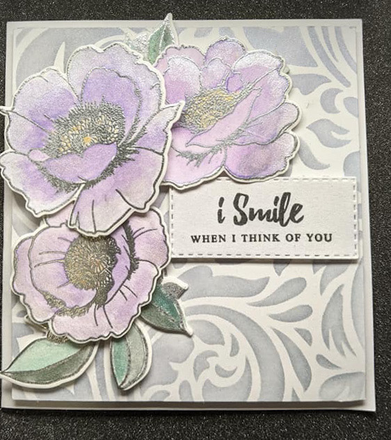 Multi lauer ink blended and stamped flowers with a base created by a stencil, embossing paste and shimmer mica.