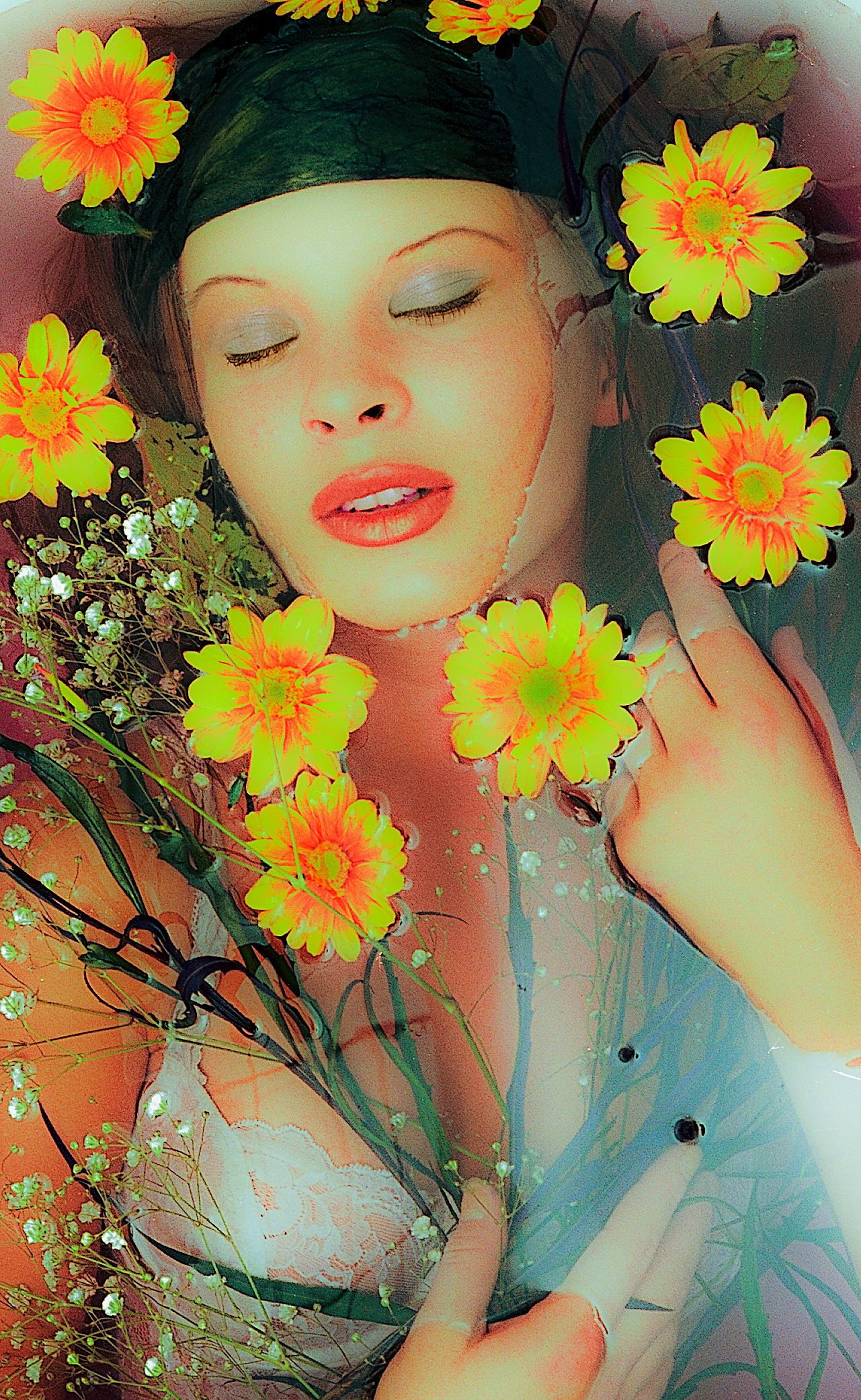 Anetka lying in water with bra surrounded by yellow/red flowers with eyes closed