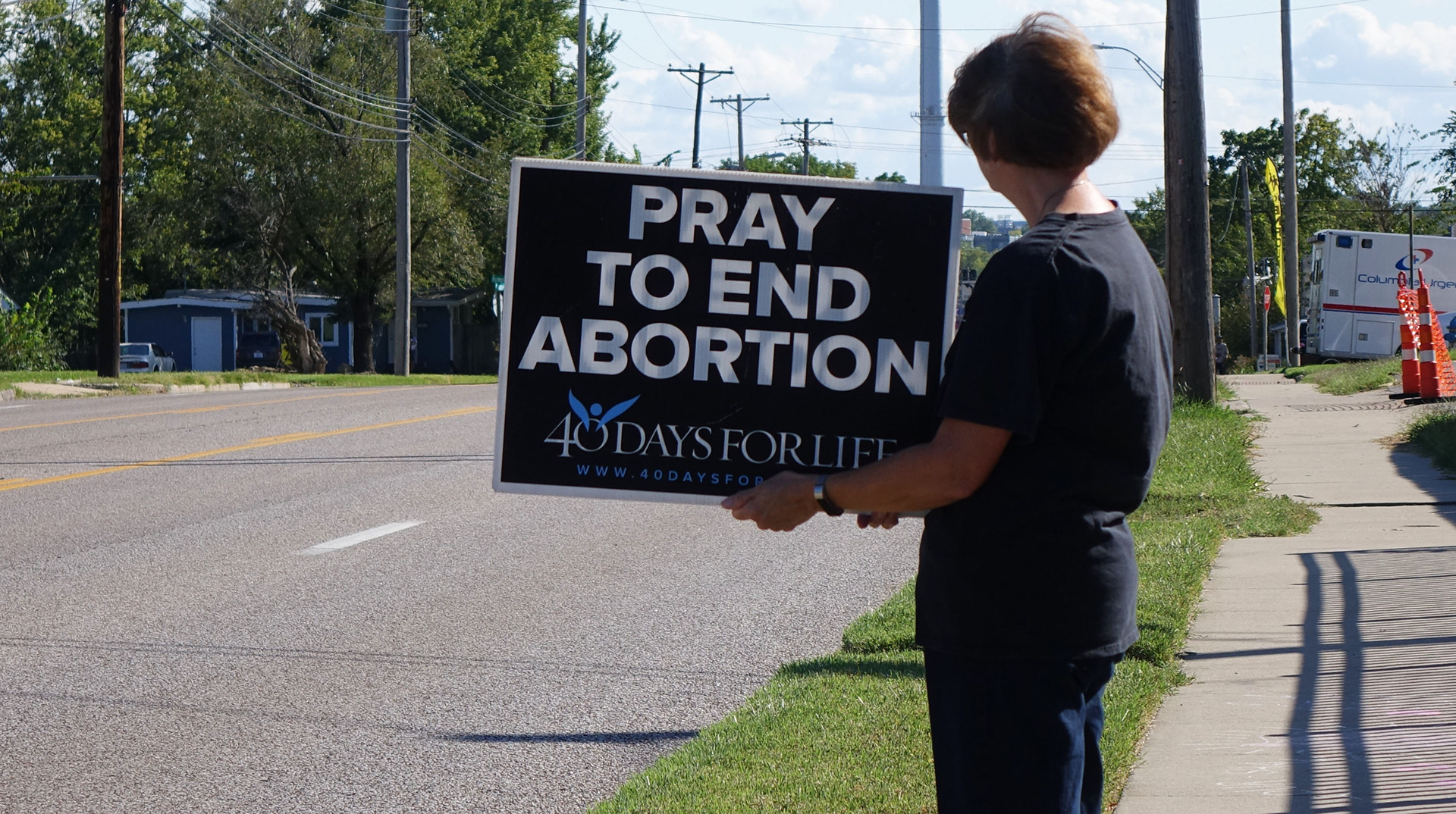 Sonia Potts holds up a sign on the sidewalk outside of Planned Parenthood as part of 40 Days for Life in Columbia, Mo., on Wednesday, Sept. 25, 2019. Cars driving past on busy Providence Road can see the activists holding signs like these until 40 Days for Life ends on Nov. 3.
