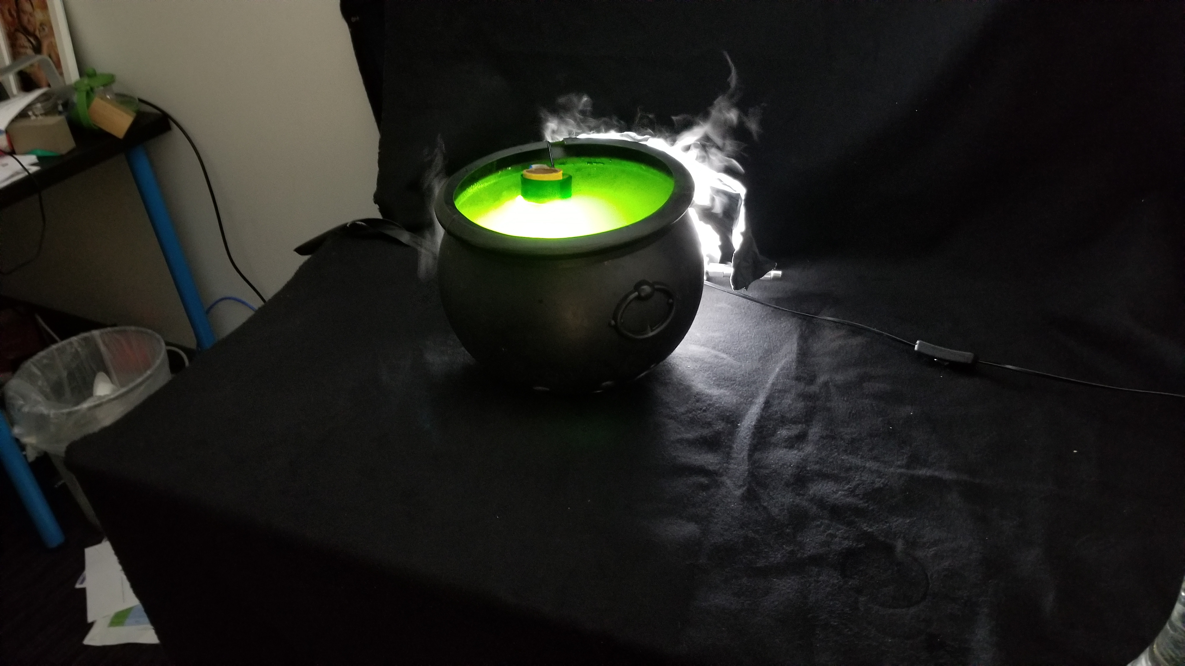 The glow and bubbling fog are added to the miniature cauldron in post.