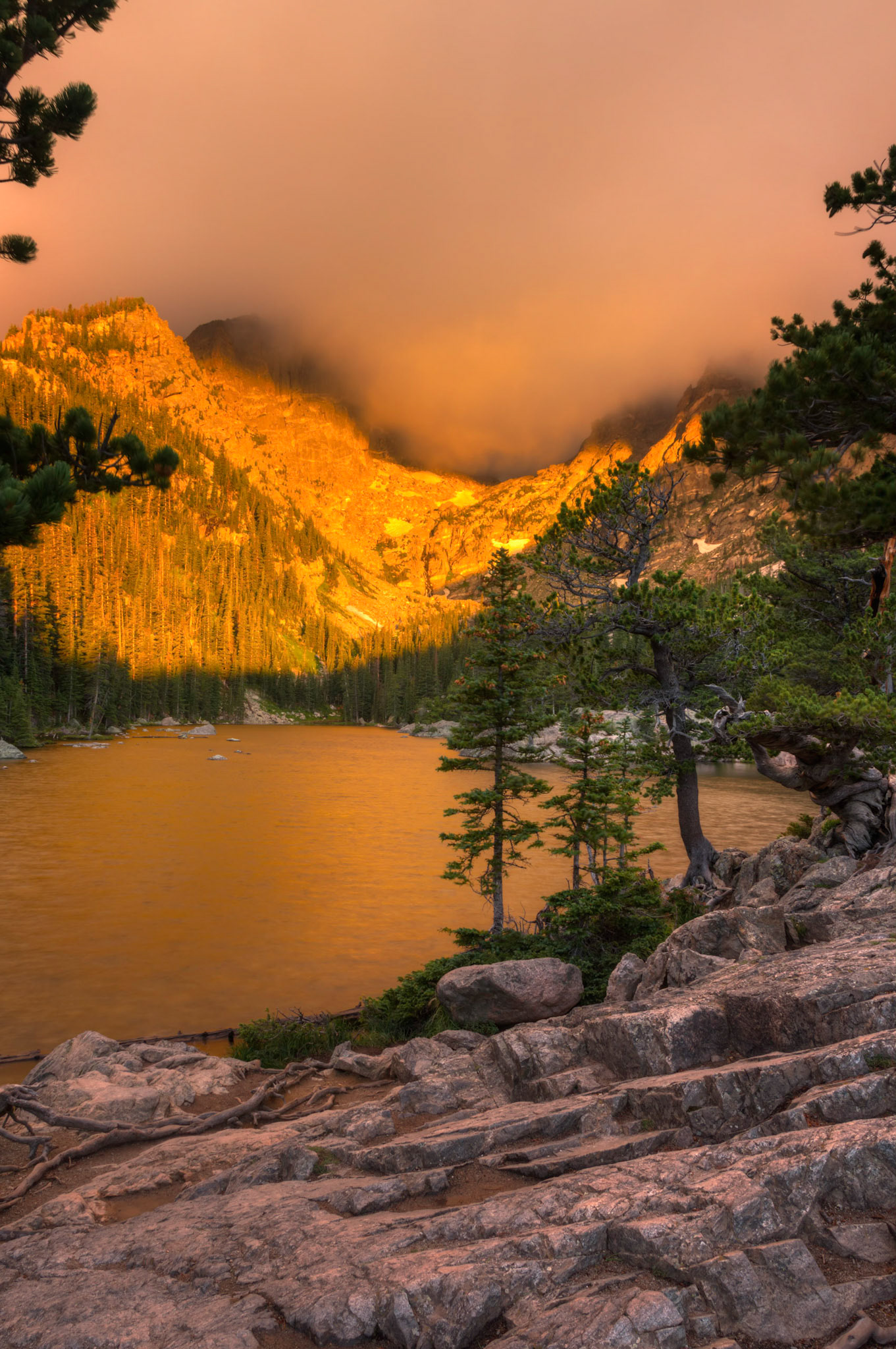 Thick clouds were hugging the tops of Hallet Peak and Flattop Mountain above Dream Lake this morning, but the sun gave a nice golden glow to their slopes as it rose. A 5 shot HDR composite merged in Photomatix Pro.  Additional processing in Lightroom and Photoshop.Rocky Mountain National Park6 August 2014PENTAX K-3, Sigma 18-250mm f/3.5-6.3 DC OS HSMISO 100 18 mm  0.6 sec at ƒ / 11Prints of my work are available from my website at http://www.fingolfinphoto.comFollow me on Facebook at http://www.facebook.com/fingolfinphoto or http://www.facebook.com/pesterleAlso, http://500px.com/pesterle   http://www.flickr.com/photos/fingolfinphoto