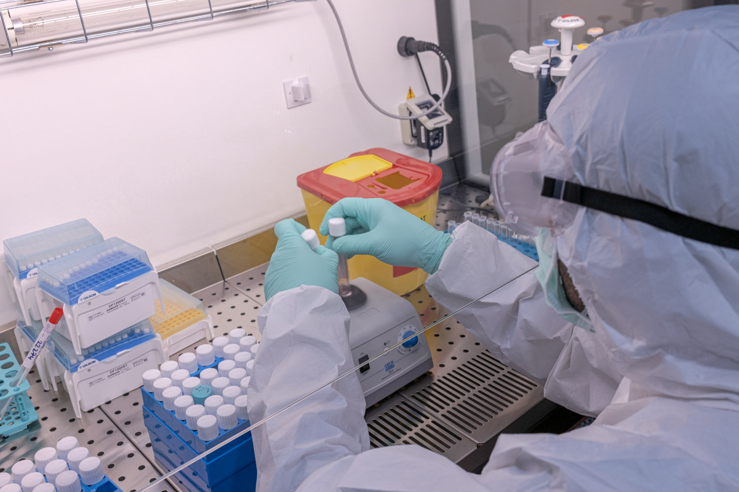 A molecular biologist wearing protective equipment as she process to extract viral RNA in a high safety laboratory chamber at a private hospital in Istanbul on 1 May 2020.