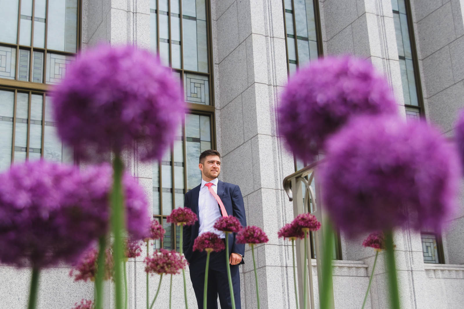 Groom at Mormon temple wedding, perspective shot with purple flowers