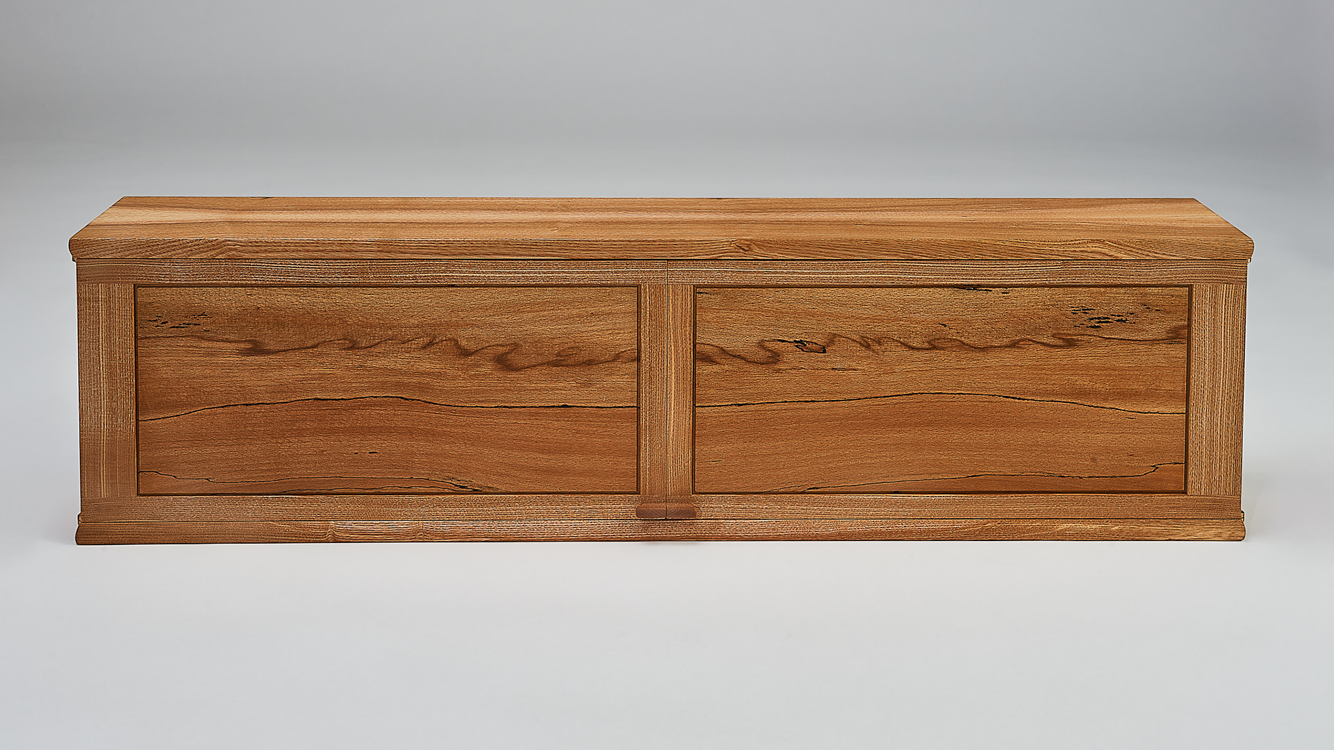 a wall mounted cabinet with two doors which open in the middle. the door panels are made of spalted beech and show a pattern across both doors
