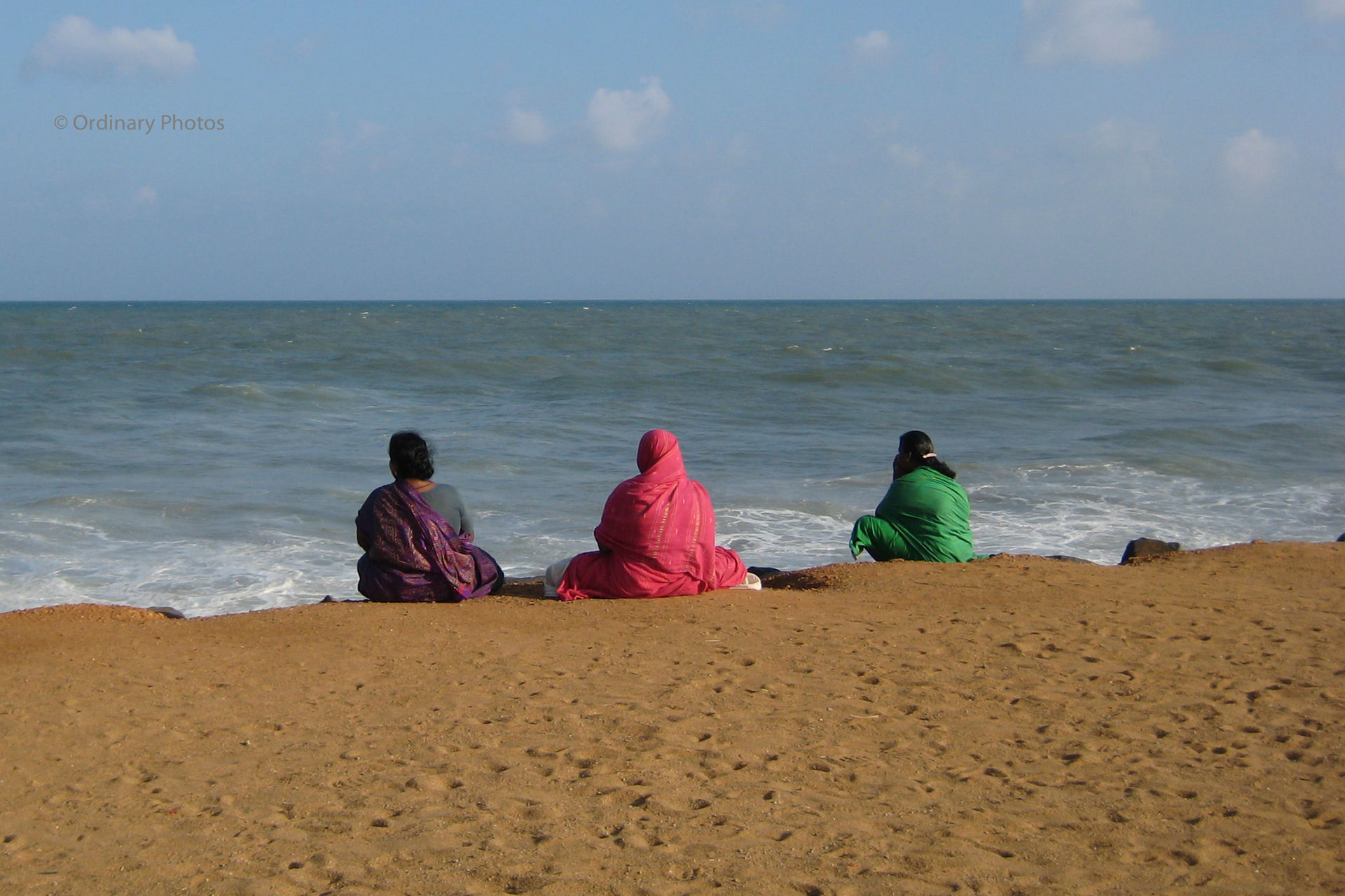 Kleurrijke vrouwen, starend naar de oceaan in Pondicherry