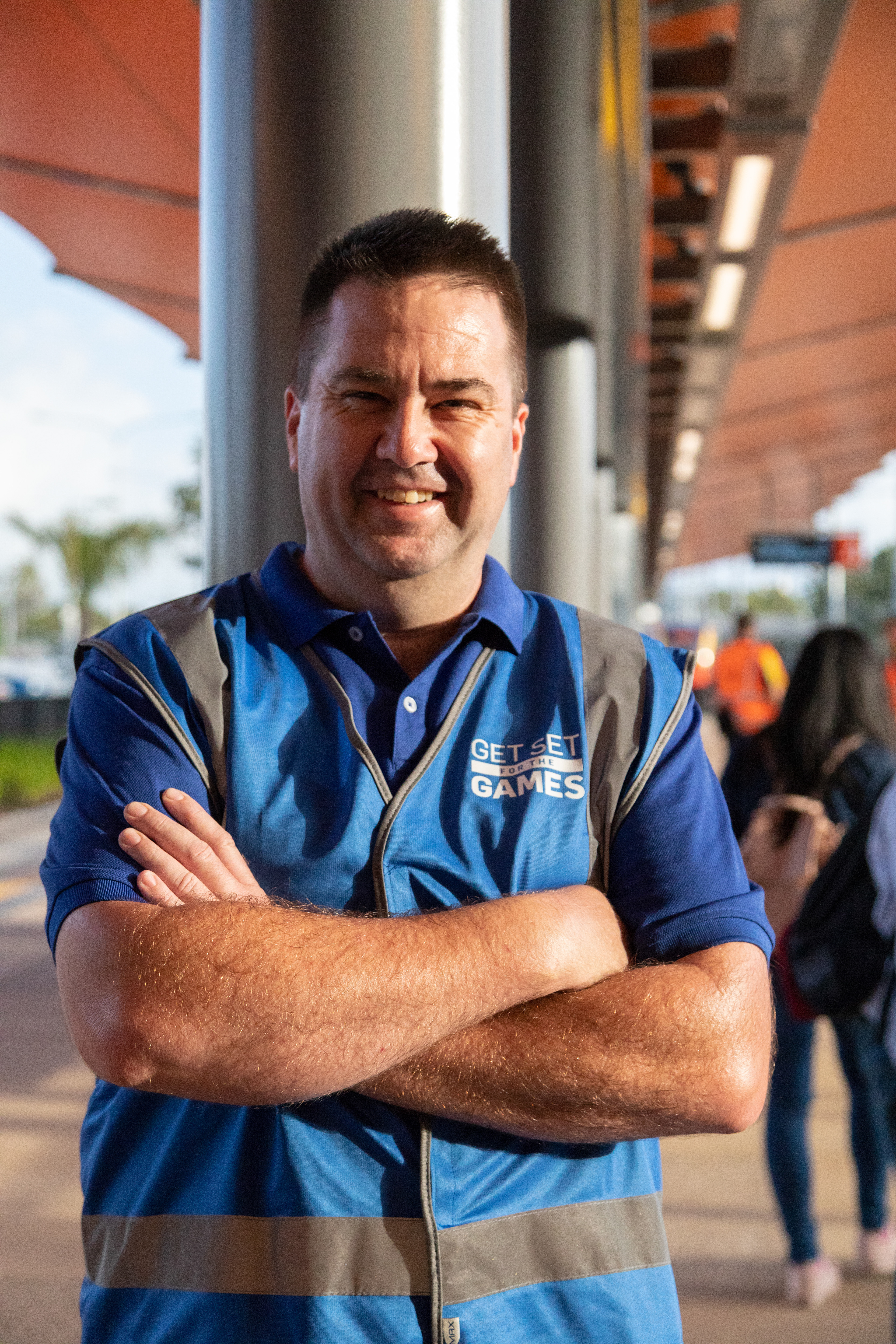 Commonwealth Games crewmember smiling with arms crossed