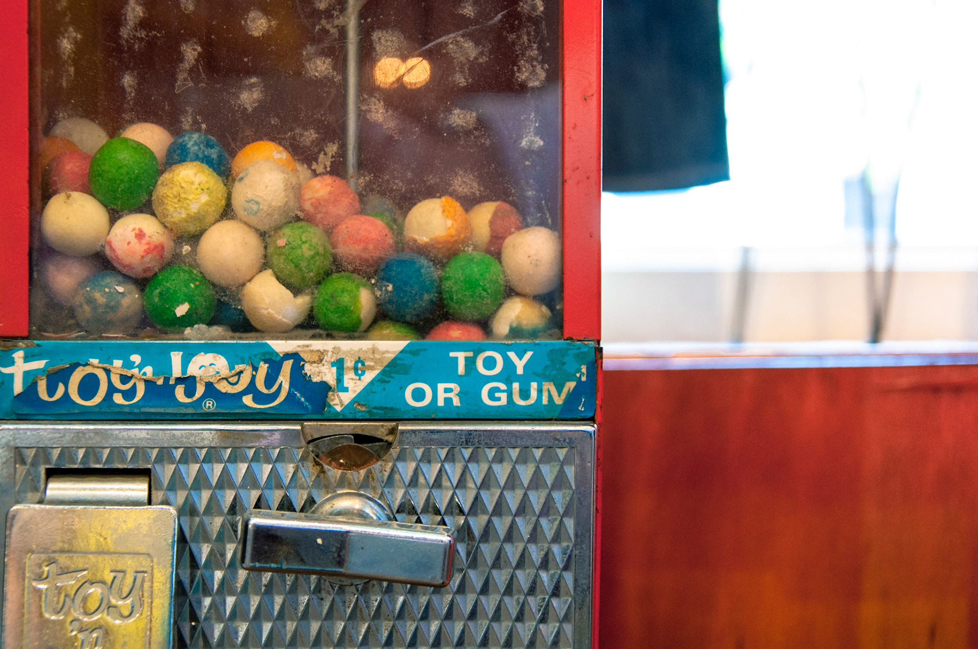 An old gumball machine complete with vintage gumballs.