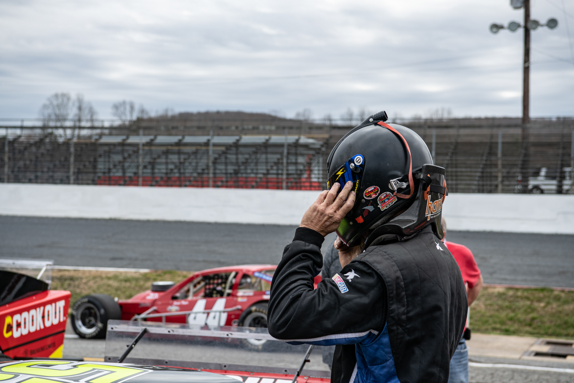 Jeremy Gerstner puts on his helmet as other drivers line up for practice at Caraway Speedway in Sophia, N.C. on March 13, 2021.
