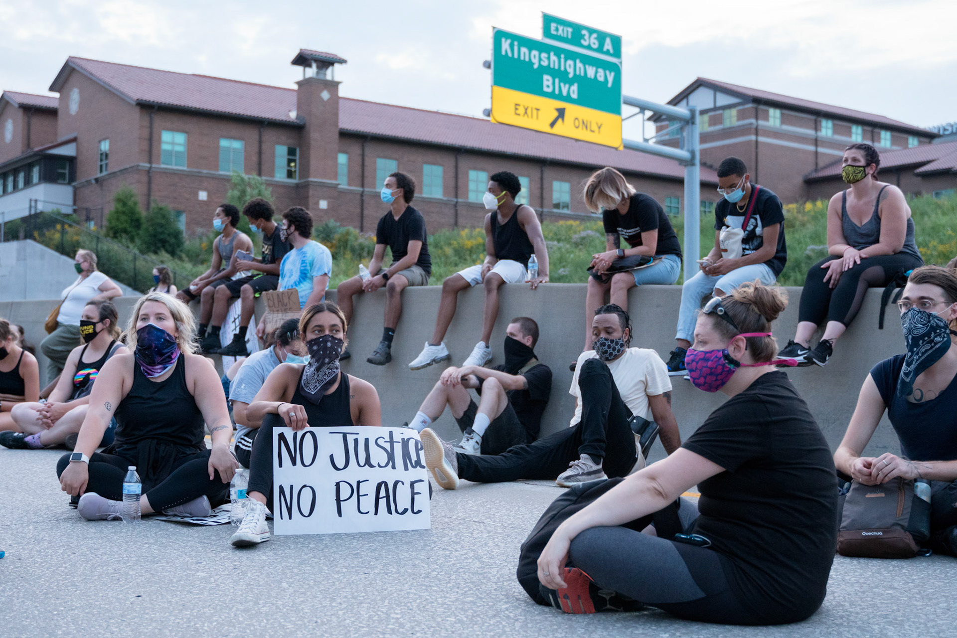 Protestors sit on I-64, shutting down the freeway, during a protest in the Central West End on Friday, July 3, 2020.