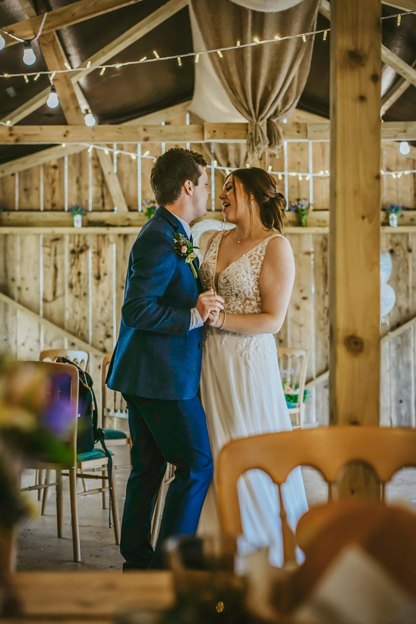 bride and groom stood close together dancing in main barn dance hall together alone celebrating being newly married in buckinghamshire