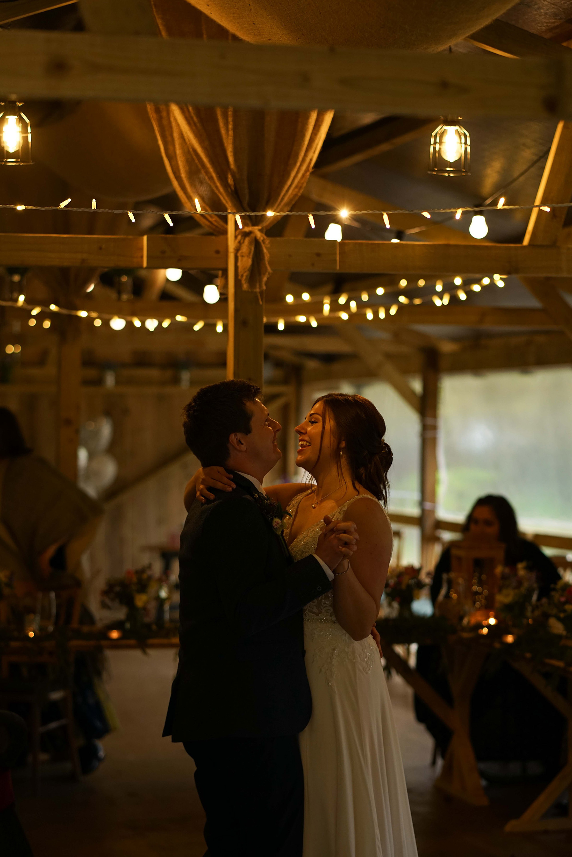 romantic late evening couples dance between bride and groom under fairy lights with candles and family and friends in warm countryside micro wedding in buckinghamshire uk