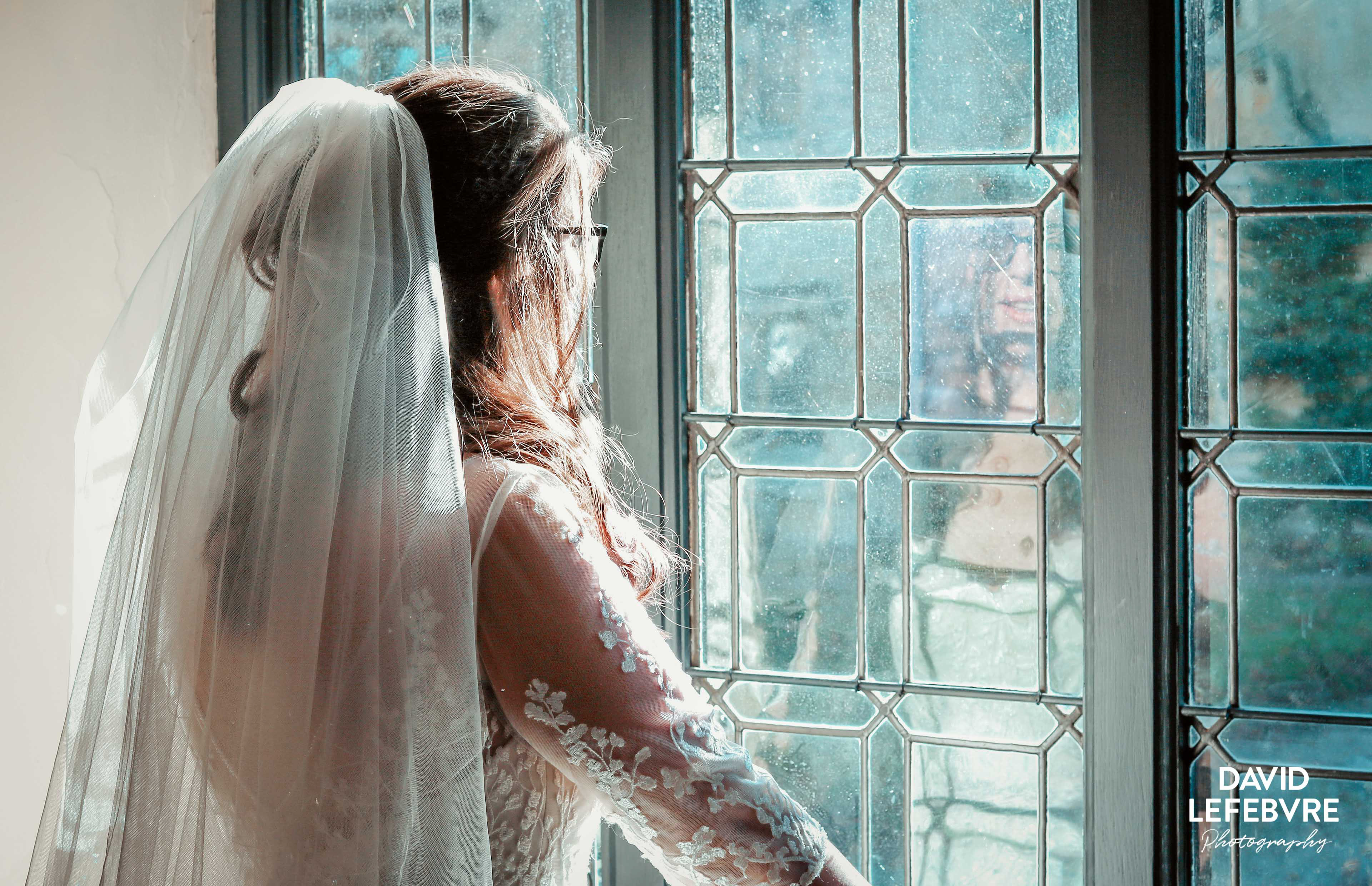 bride in dress looking out of window