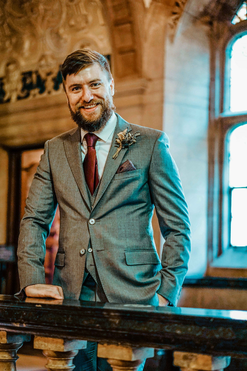 smiling groom stood in oxford town hall in ted baker suit with wedding photographer david lefebvre