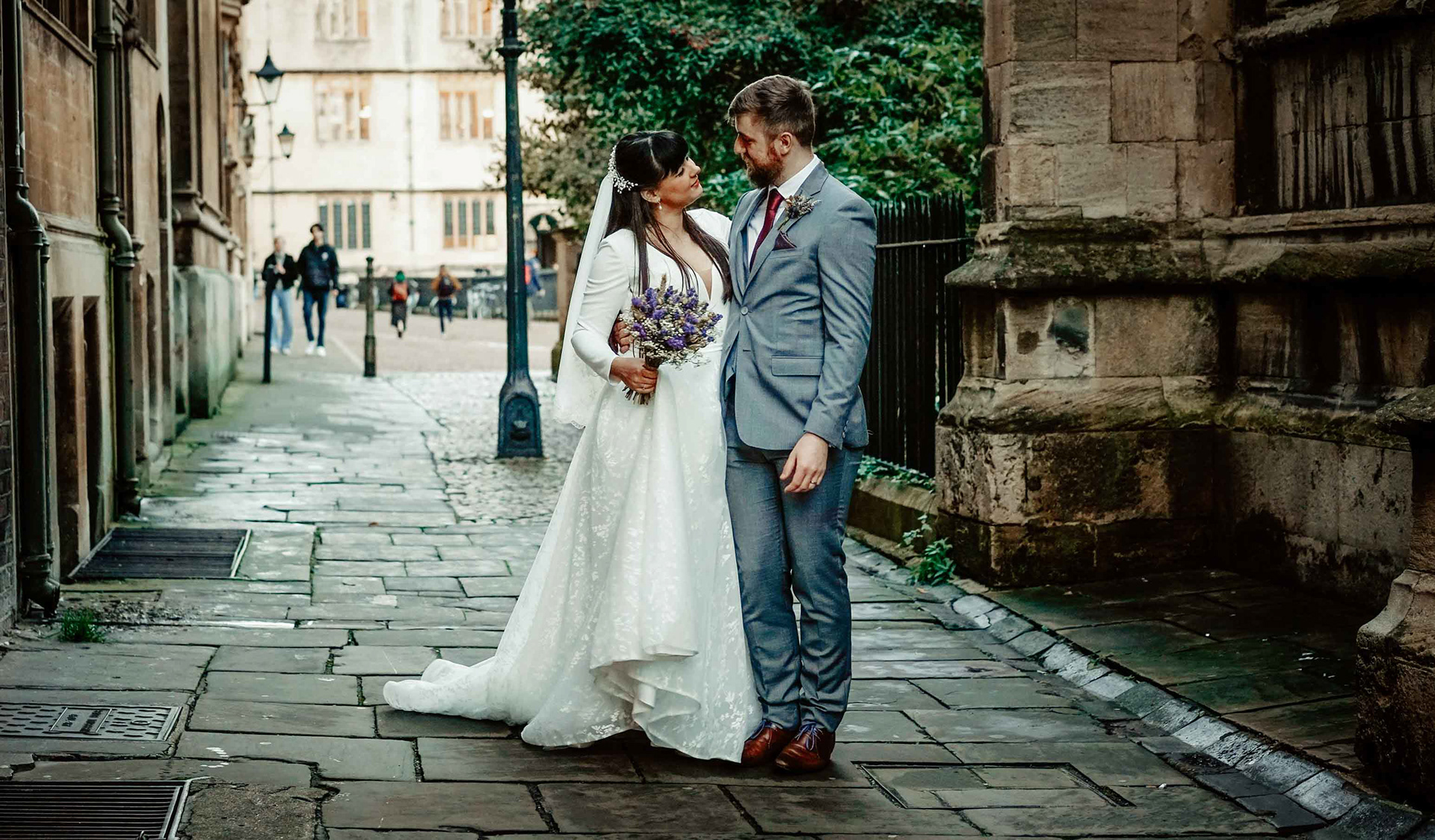 intimate shot by photographer david lefebvre of smiling bride and groom stood in oxford street near radcliffe camera at december covid wedding