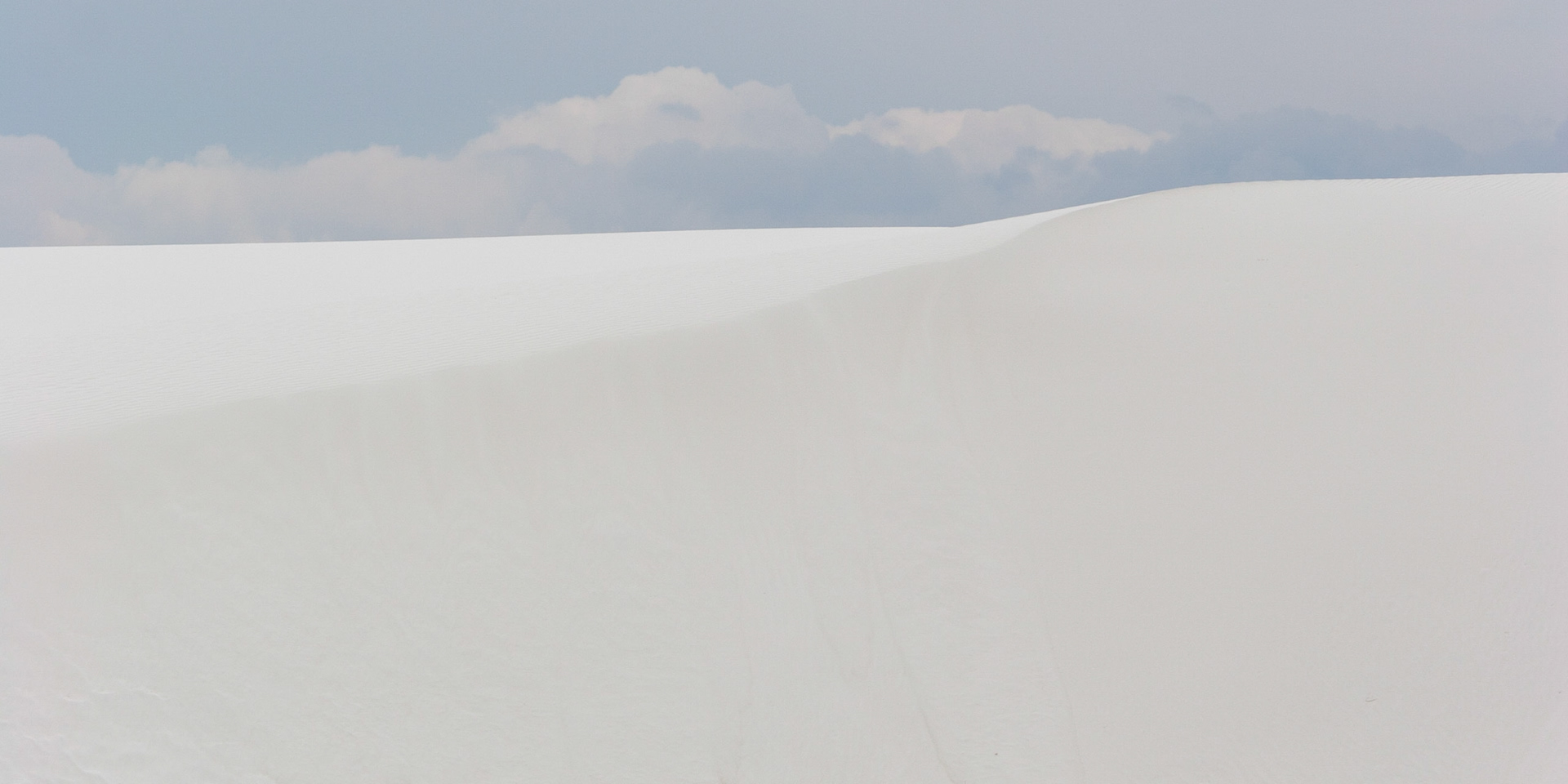 White Sands National Monument, New Mexico. Rising from the heart of the Tularosa Basin is one of the world's great natural wonders - the glistening white sands of New Mexico. Great wave-like dunes of gypsum sand have engulfed 275 square miles of desert, creating the world's largest gypsum dunefield. White Sands National Monument preserves a major portion of this unique dunefield, along with the plants and animals that live here.