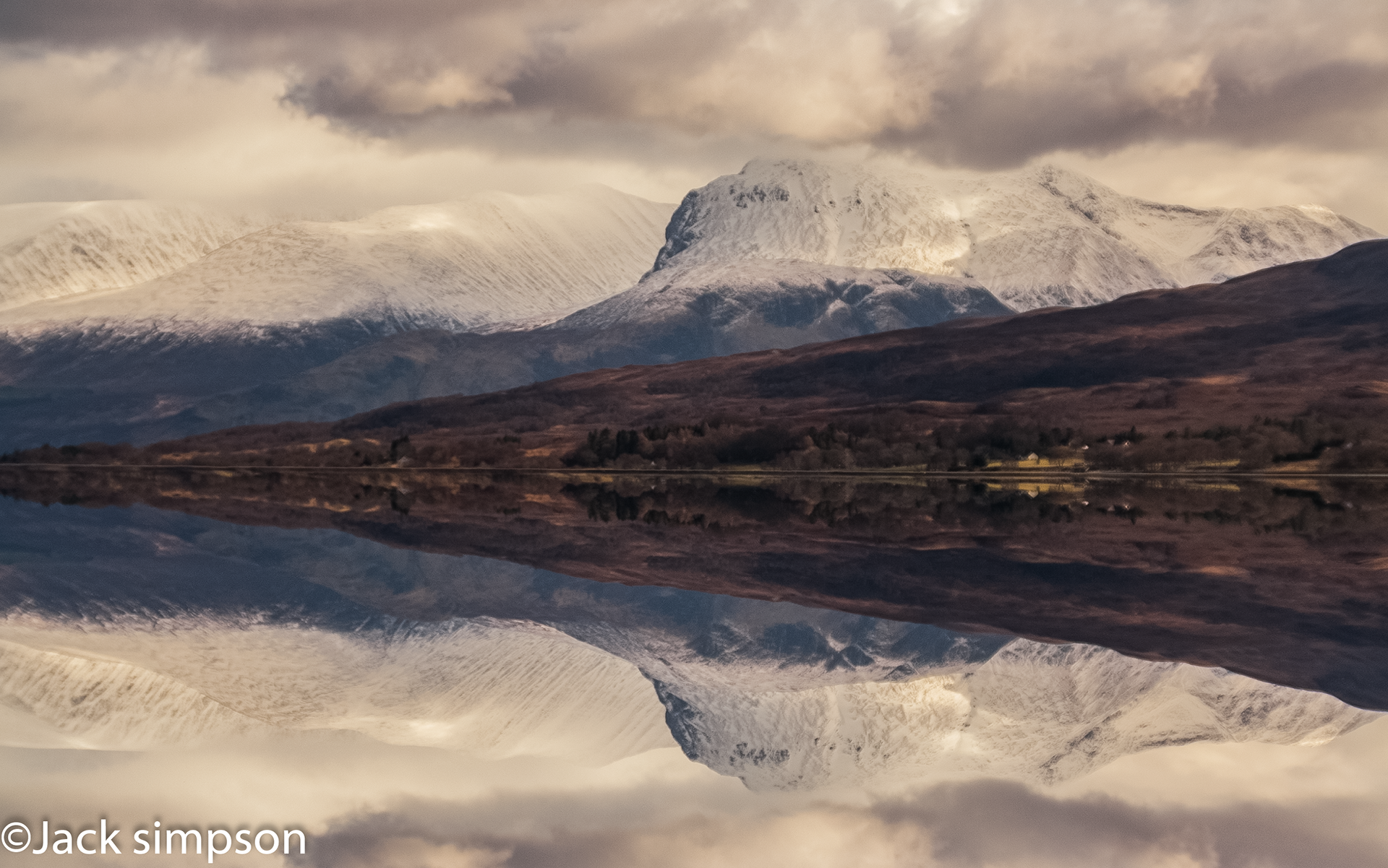 A winter image of Ben Nevis reflected in the calm and still waters of Loch Eil, Lochaber, Scotland