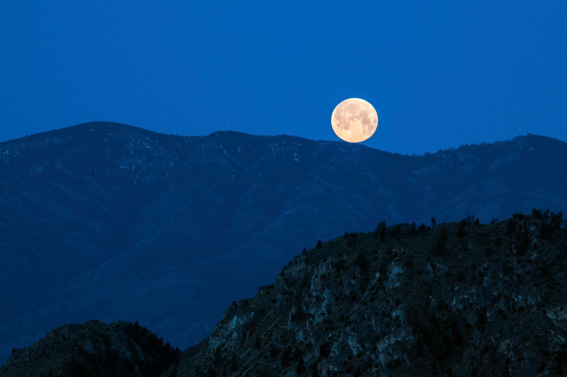 The parigee moon sets over the hills near Brewster Washington.
