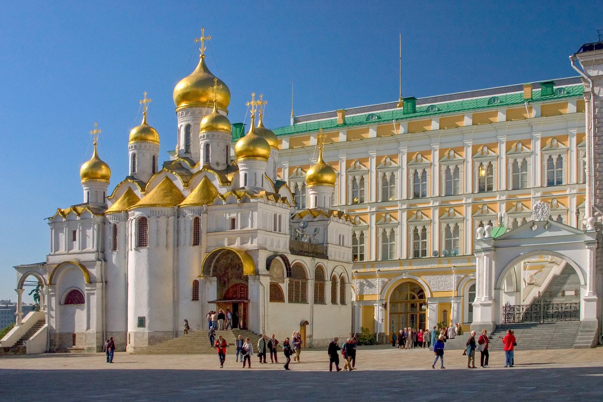 The Cathedral of the Annunciation with the Great Kremlin Palace and the edge of the Faceted Palace behind it. The photo is taken from the cathedral square inside the Kremlin in Moscow.