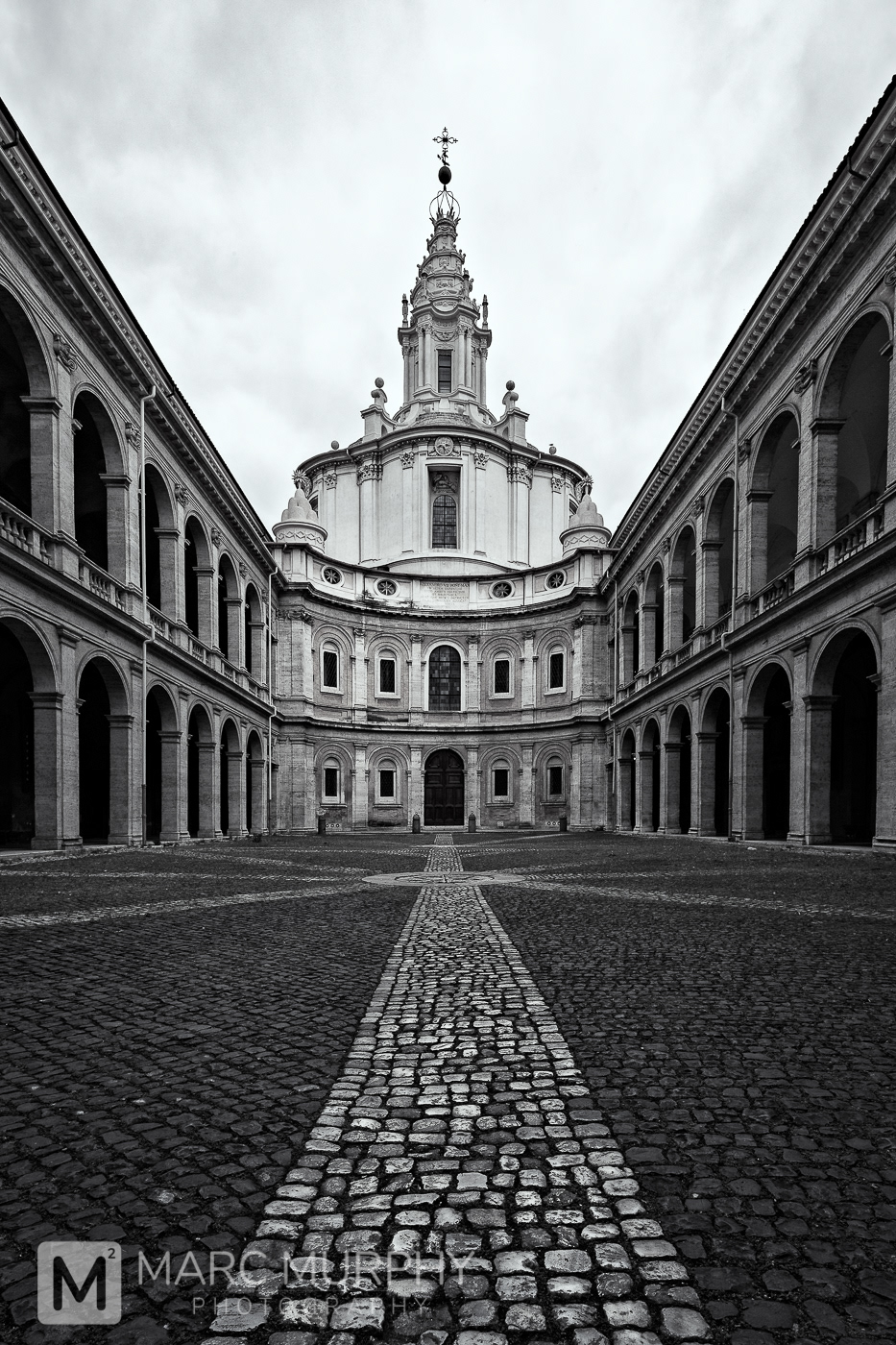 Black and White St. Ivo alla Sapienza Church Courtyard in Rome Italy with a Stone Path Leading to a Spiral Steeple and Cross