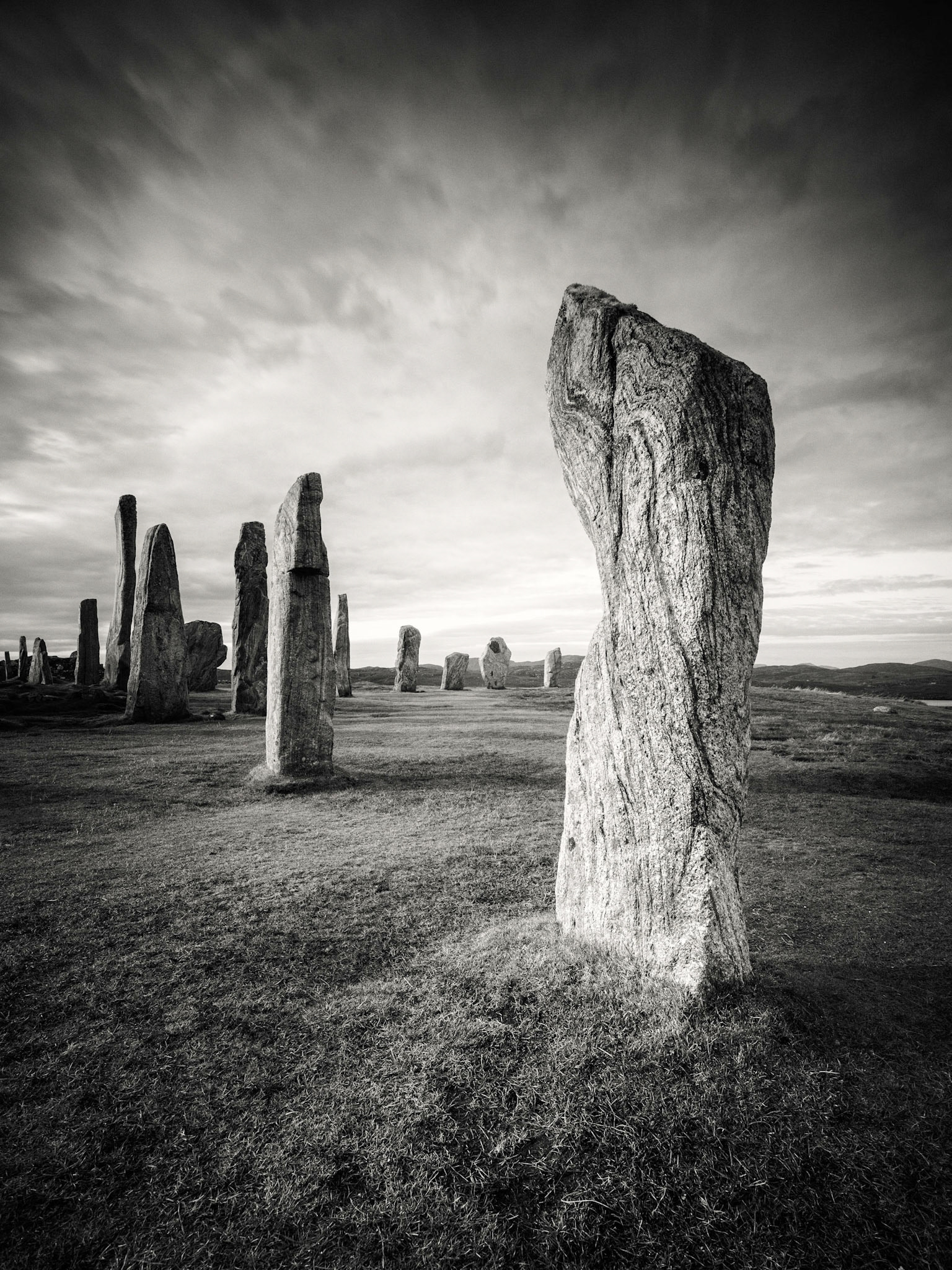 My first visit to Calanais but hopefully not my last. There was a constant stream of visitors but I noticed that few stayed long. I wanted to capture the atmosphere of this wonderful site, and a long exposure felt perfect to soften the sky and balance the harsh stone. Although many of the stones have great features, this stone had an intriguing flowing texture.