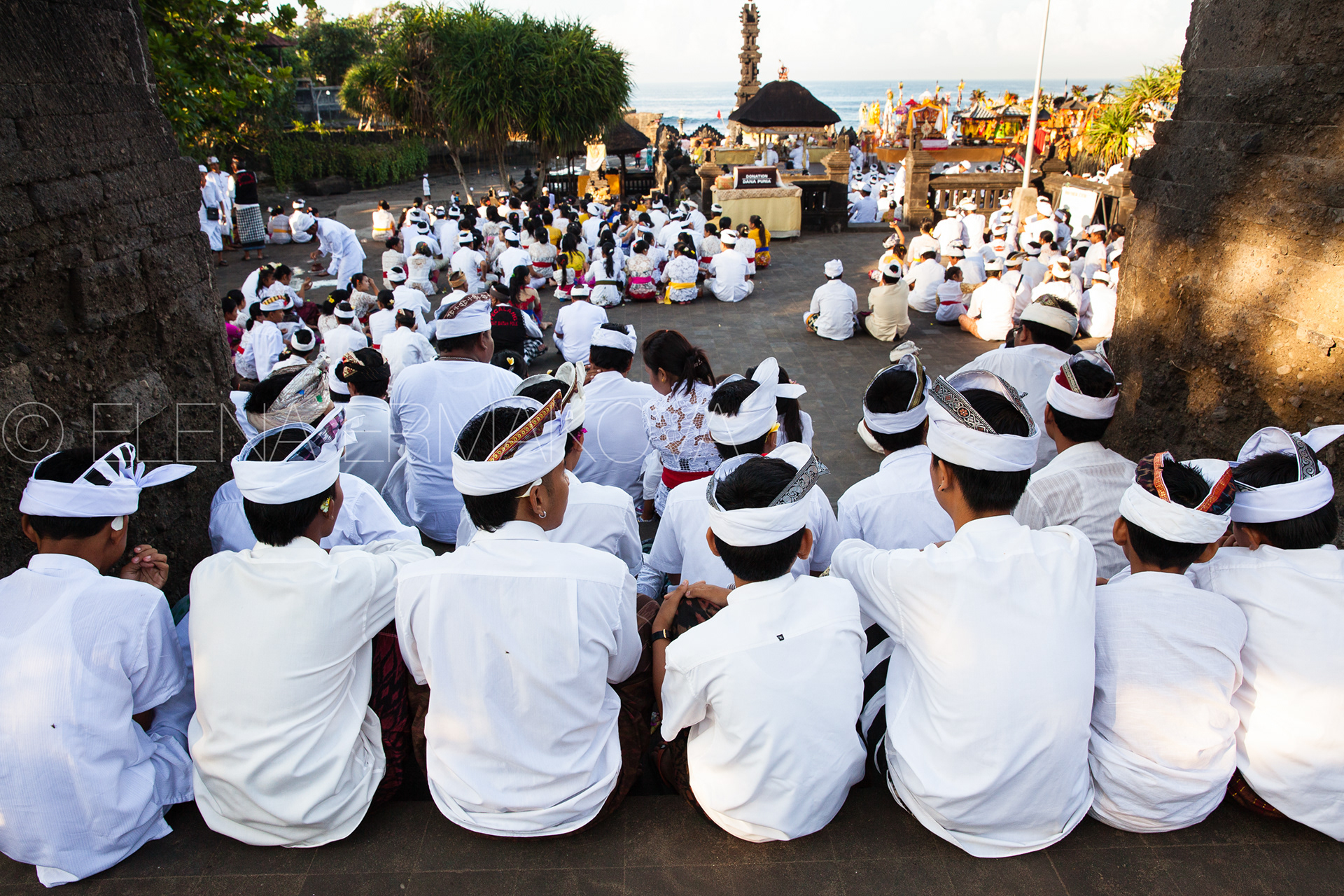 Balinese people in traditional white clothes wait for religious ceremony commemorated to Nyepi celebrations, Bali, Indonesia.