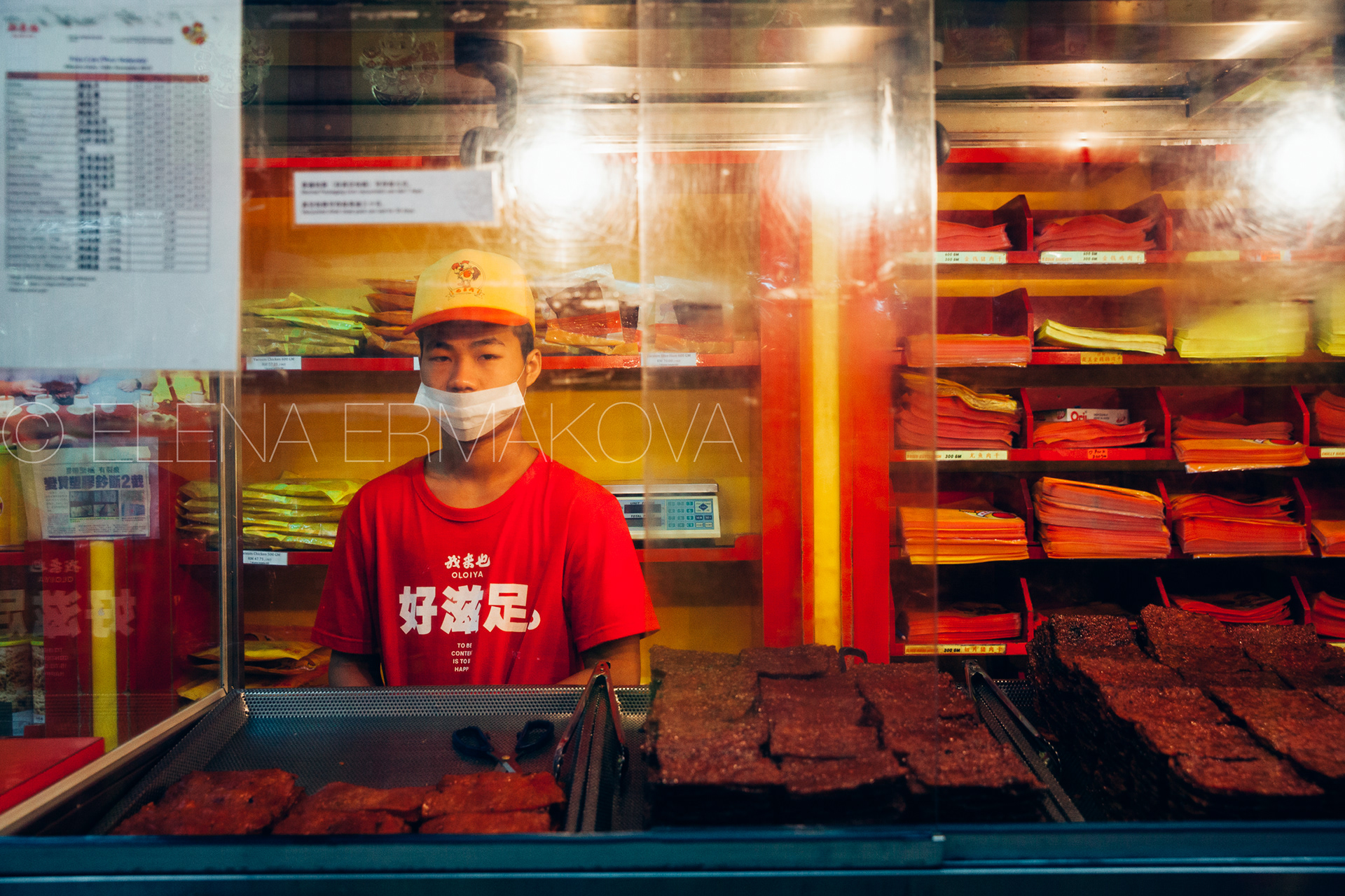 Young man sells chinese dried meat (Bakkwa) at the street food stall in Chinatown, Kuala Lumpur, Malaysia