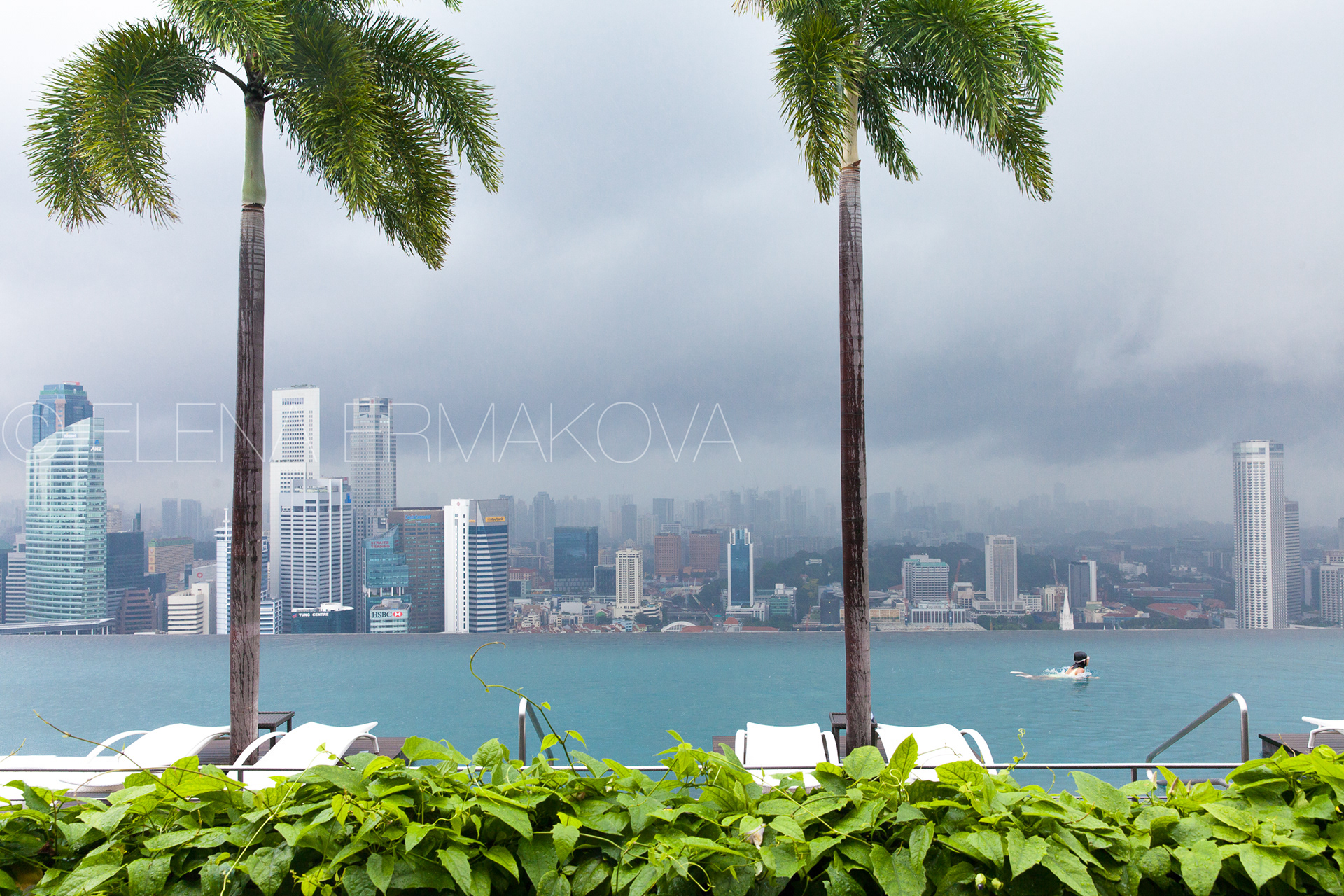 Girl swims in Infinity Pool on the roof of Marina Bay Sands Hotel, Singapore. Travel photography by Elena Ermakova.
