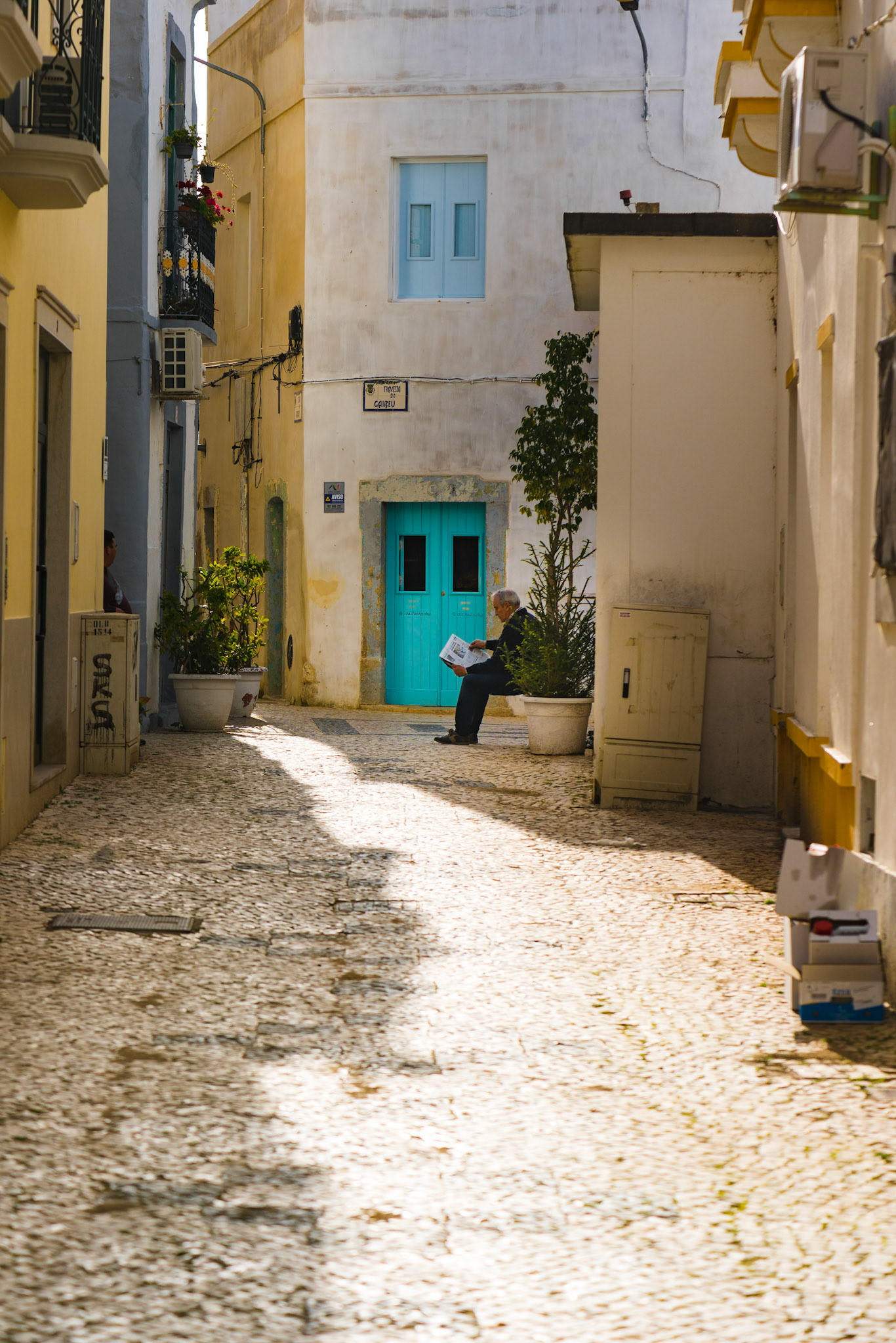 Man reading a magazine in a old village in Portugal during his break.
