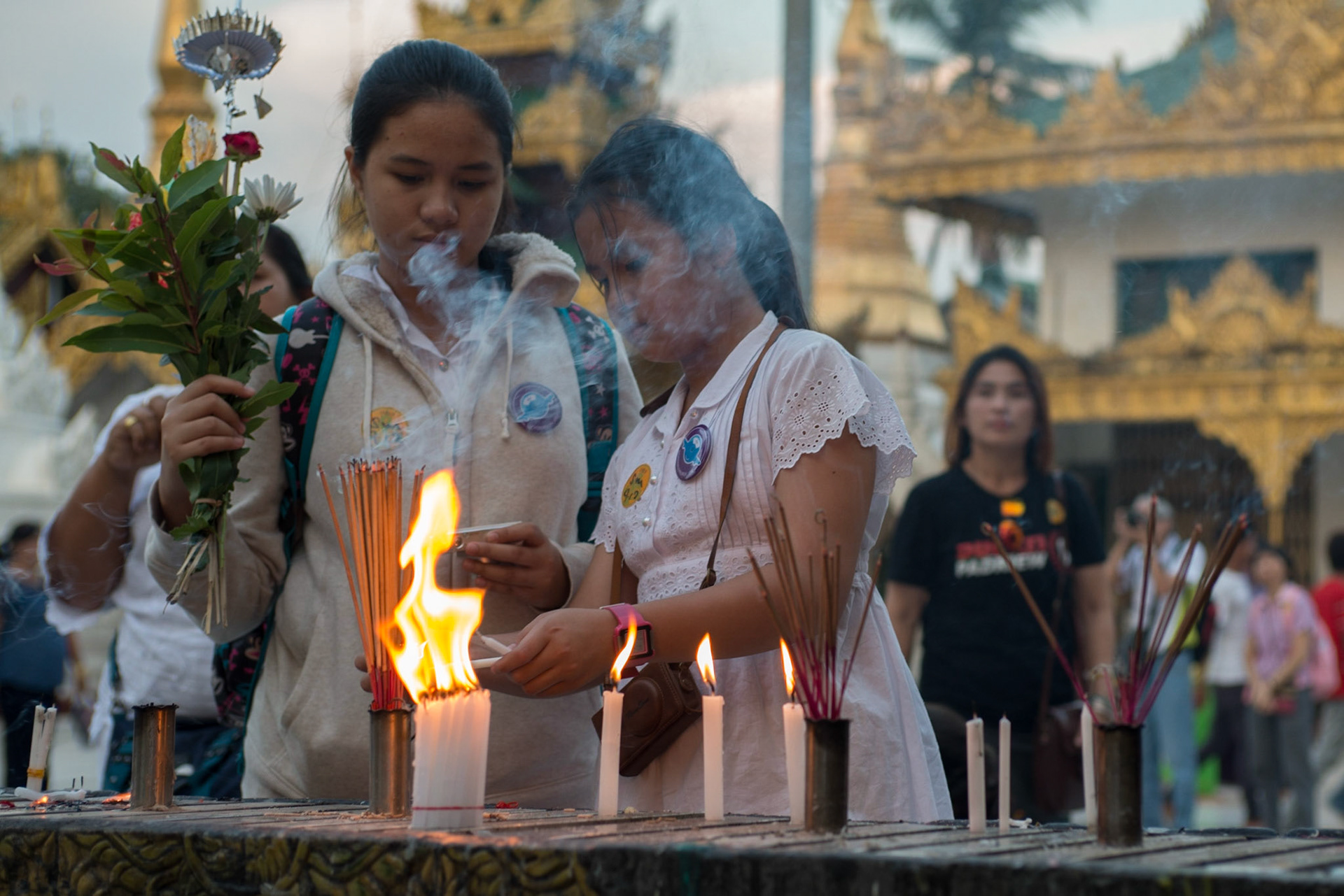 According to legend, the Shwedagon Pagoda has existed for more than 2,600 years, making it the oldest historical pagoda in Burma and the world. According to tradition, two merchant brothers, Taphussa and Bhallika, from the land of Ramanya, met the Lord Gautama Buddha during his lifetime and received eight of the Buddha's hairs in 588 BCE. The brothers traveled back to their homeland in Burma and, with the help of the local ruler, King Okkalapa of Burma, found Singuttara Hill, where relics of other Buddhas preceding Gautama Buddha had been enshrined. When the king opened the golden casket in which the brothers had carried the hairs, incredible things happened:“	There was a tumult among men and spirits ... rays emitted by the Hairs penetrated up to the heavens above and down to hell ... the blind beheld objects ... the deaf heard sounds ... the dumb spoke distinctly ... the earth quaked ... the winds of the ocean blew ... Mount Meru shook ... lightning flashed ... gems rained down until they were knee deep ... all trees of the Himalayas, though not in season, bore blossoms and fruit.[3]	”Shwedagon Pagoda after World War IIAccording to some historians and archaeologists, however, the pagoda was built by the Mon people between the 6th and 10th centuries CE.The stupa fell into disrepair until the 14th century, when the Mon king Binnya U of Bago had the stupa rebuilt to a height of 18 m (59 ft). A century later, Queen Shinsawbu (1453–72), Dhammazedi's mother-in-law, raised its height to 40 m (131 ft). She terraced the hill on which it stands, paved the top terrace with flagstones, and assigned land and hereditary slaves for its maintenance. She yielded up the throne to Dhammazedi in 1472, retiring to Dagon; during her last illness she had her bed placed so that she could rest her dying eyes upon the gilded dome of the sacred fane. The Mon face of the Shwe Dagon inscription catalogues a list of repairs beginning in 1436 and finishing during Dhammazedi's reign. It mentions Queen Shinsawbu under a Pali name of sixty-six letters. By the beginning of the 16th century the pagoda had become the most famous place of pilgrimage in Burma.[4]