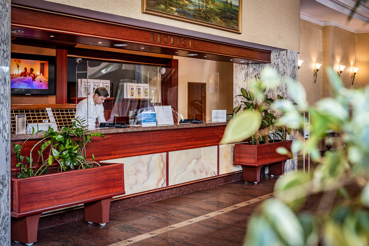recepcjonista w lobby hotelowym pracujący na komputerze