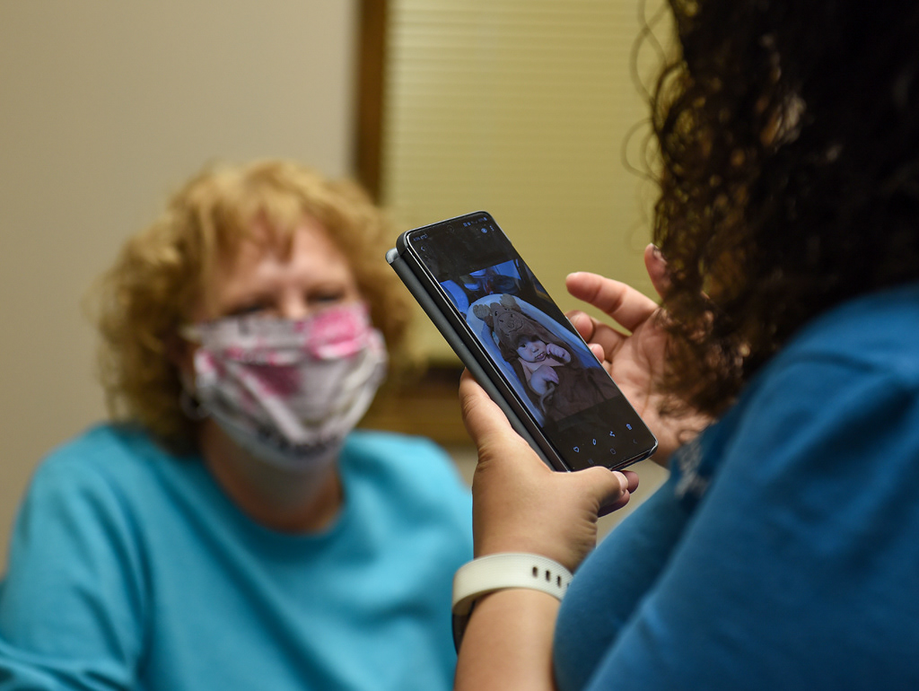 Sarah Kirchhoff pulls up a photo of her three-month-old son, Aiden, to show Glenda Fuchs on Tuesday, April 28, 2020 at the Western Missouri Family Healthcare clinic in Concordia. Fuchs came to the clinic to get a blood test, which the practical nurse at the clinic handles, but Kirchhoff stopped in her room to say hello. “In general people are concerned and being cautious, but not overly panicked,” Kirchhoff said of the atmosphere in Concordia. “If something like this happened 20 or 30 years ago when we didn't have Facebook and Skype and all those different ways that we can connect with people, it would definitely be a very different situation,” Kirchhoff said.