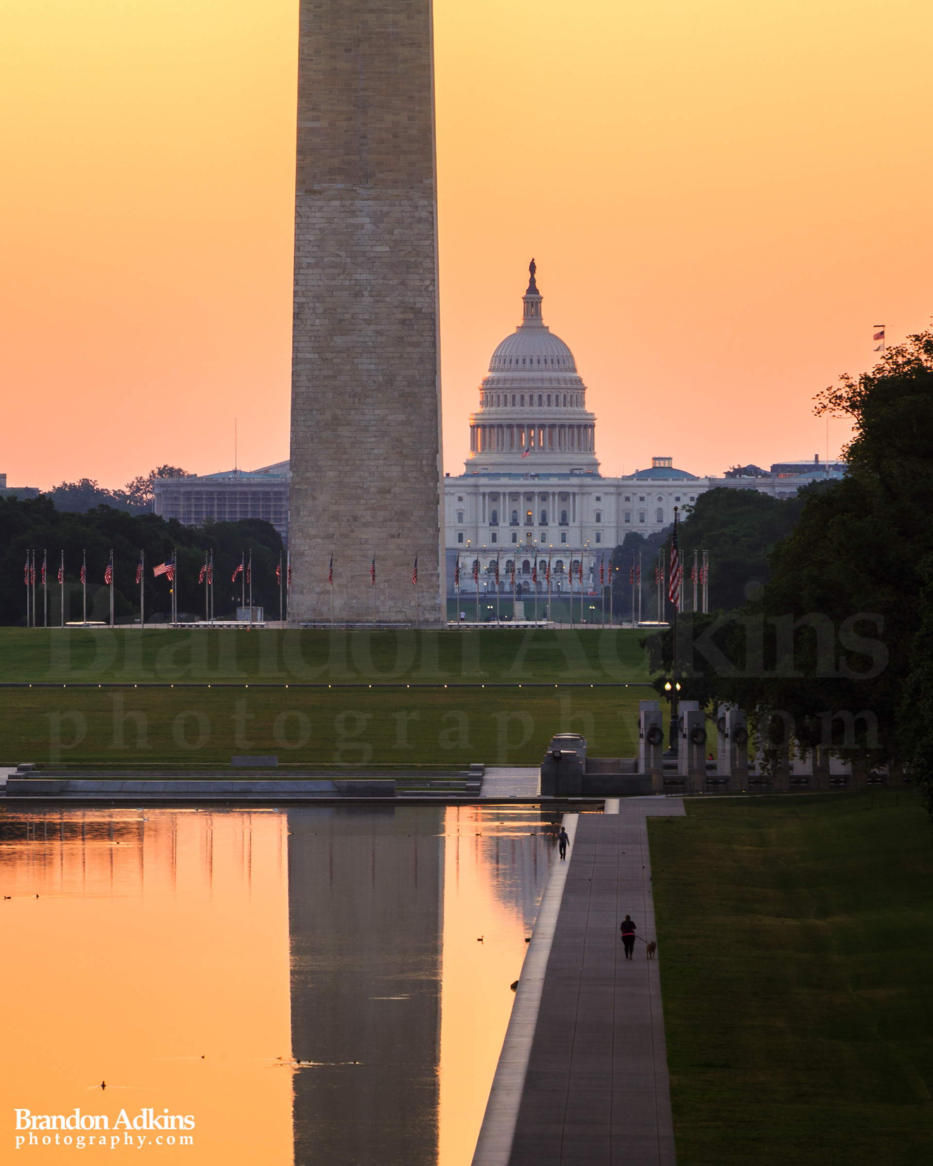 Fine art photograph of Washington Monument reflecting in Reflecting Pool with Capitol Building in the background during orange and gold sunrise in Washington, DC