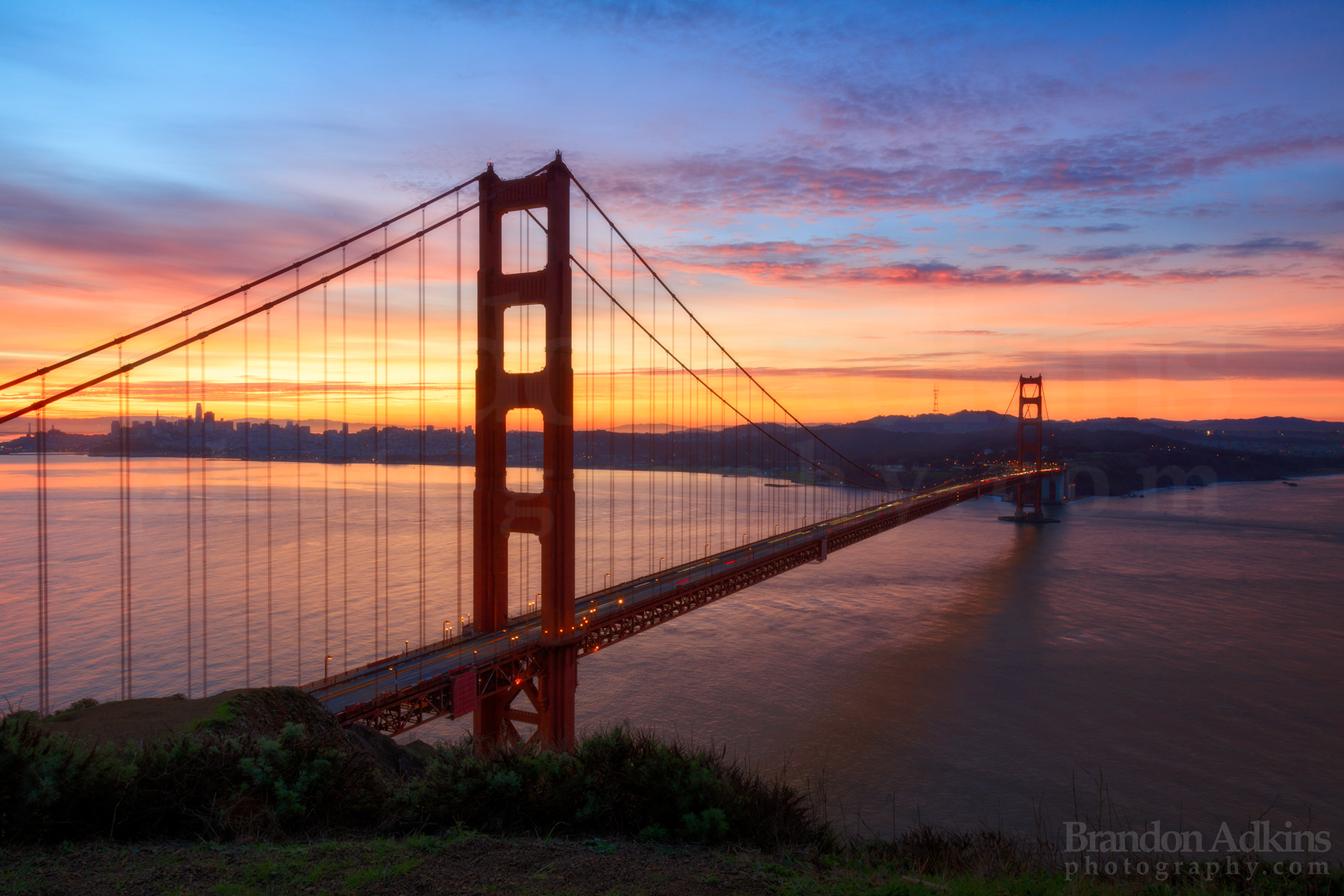 Fine art photograph of Golden Gate Bridge during beautiful colorful sunrise over the bay in San Francisco, California