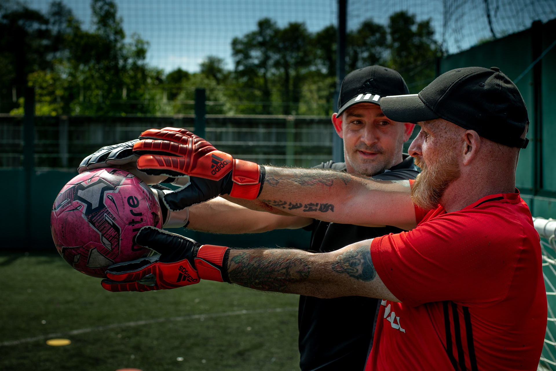 Ex Welsh Homeless Football World Cup goal keeper, Martyn hands the new goalkeeper Mark the ball in a one to one training in the Newport grounds, UK , 22nd May 2019. Ex players often remain involved with Street Football Wales in some way.
