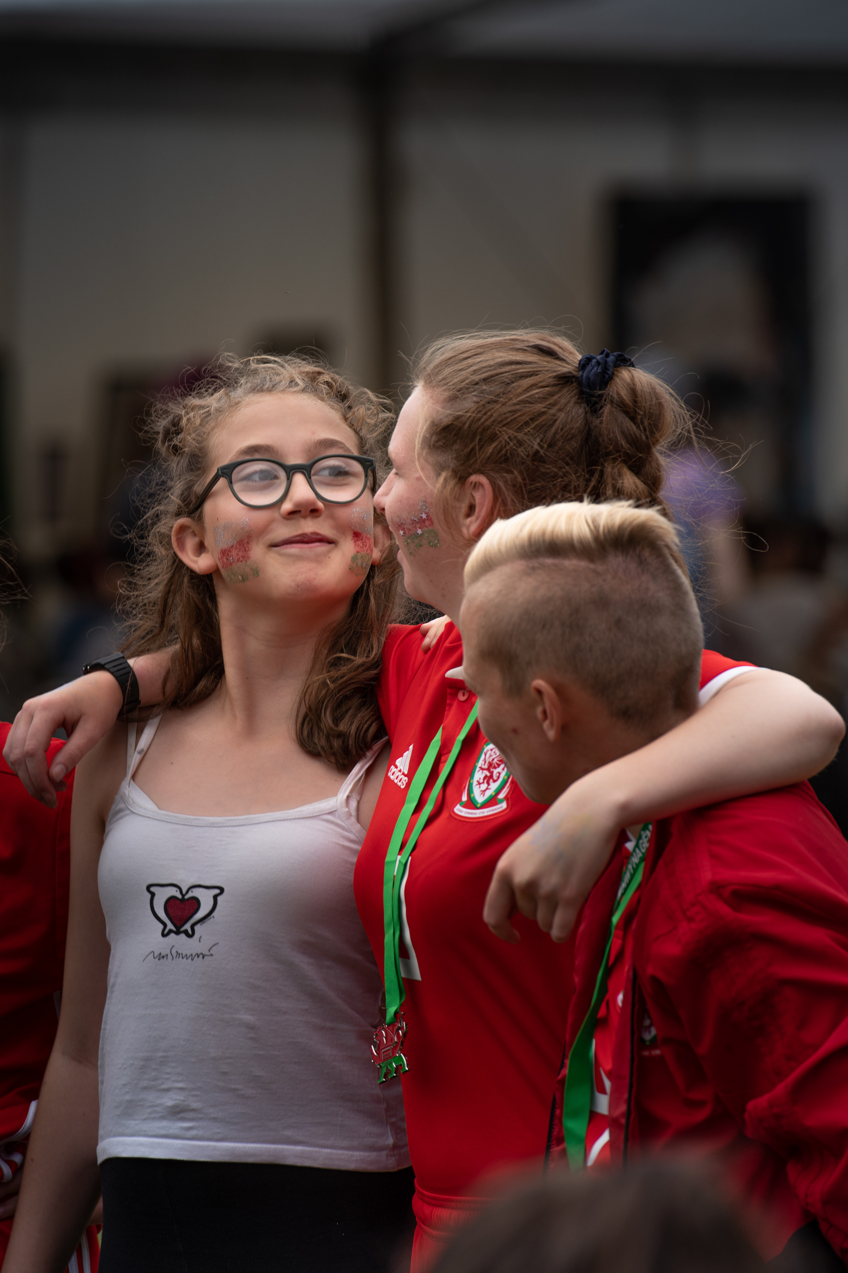 A young aspiring footballer is befreinded by Chloe and Jade from Wales' womens Homeless Football World Cup team in Cardiff, UK, 3rd August, 2019. All team members were ready to engage with the public during the tournament.