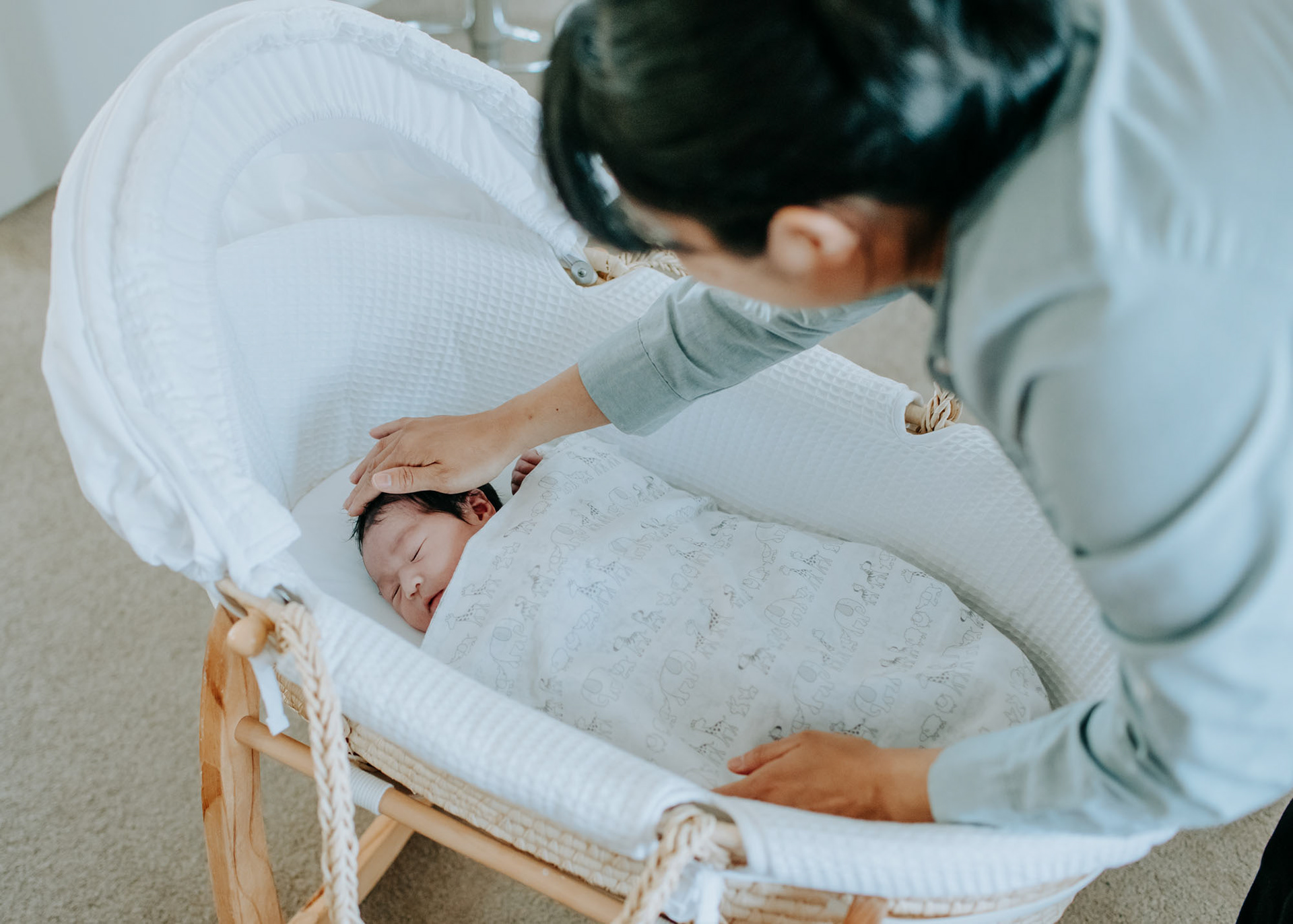 Newborn baby being soothed to sleep by proud mum