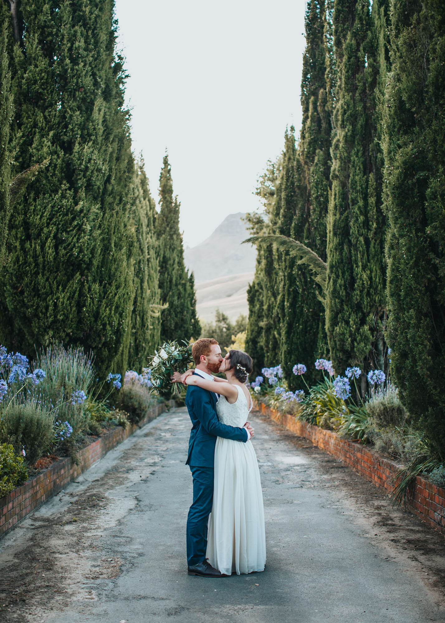 Bride Frederica and groom Calum spending time down the driveway of Belmount Gardens