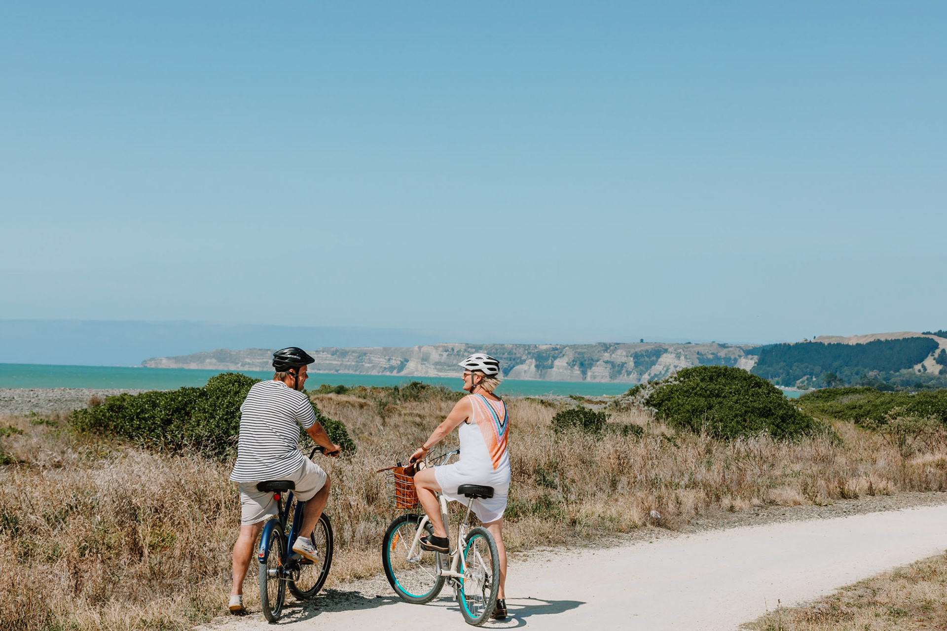 Cyclists admiring the view out to the Cape Kidnappers on a summer's afternoon