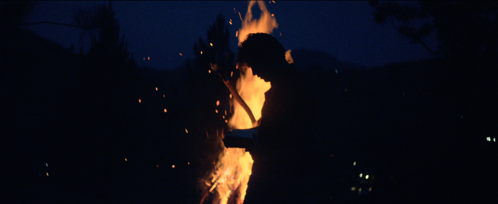 Shot of the hero character in front of a bon fire. He uses the product to write. Location: Sri Lanka / Asia